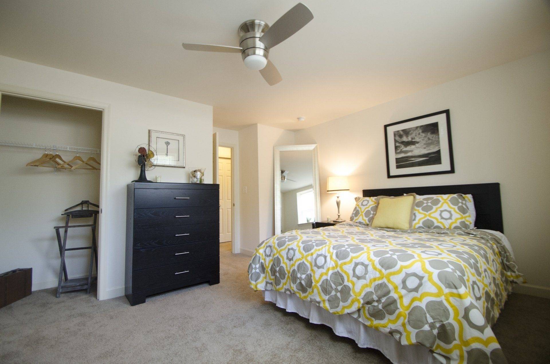 West Chester, PA Apartments - Audubon Pointe - Furnished Bedroom with Spacious Closet, Plush Carpeting, and Ceiling Fan