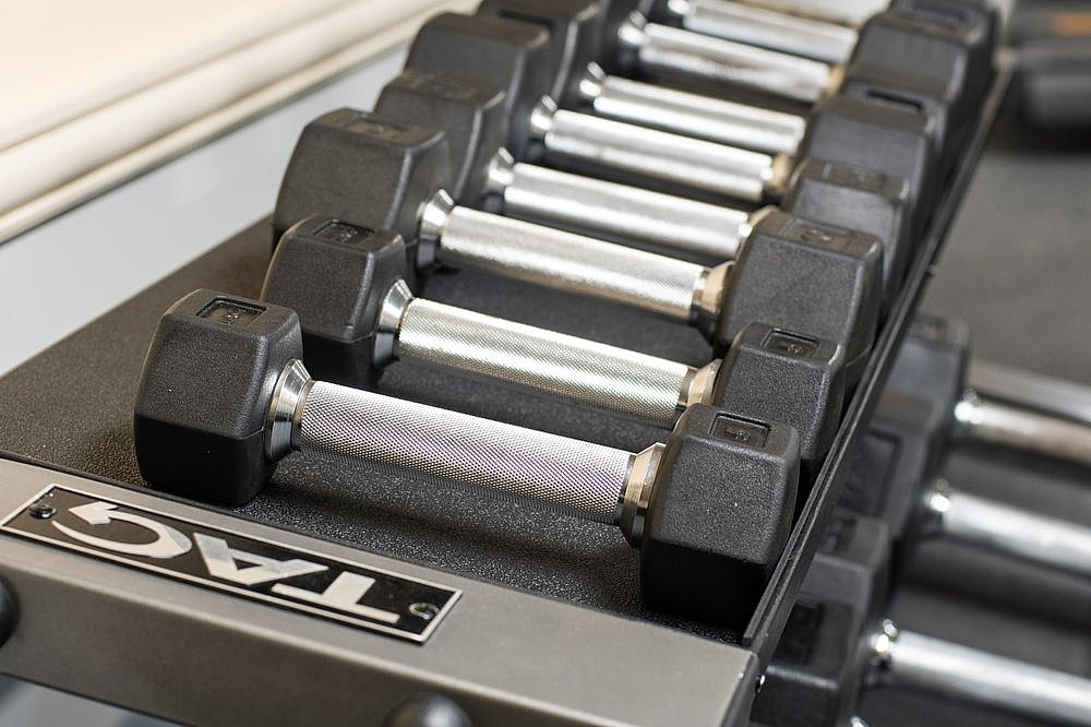 Close-up of a sleek dumbbell set neatly arranged on a rack in a modern fitness center.
