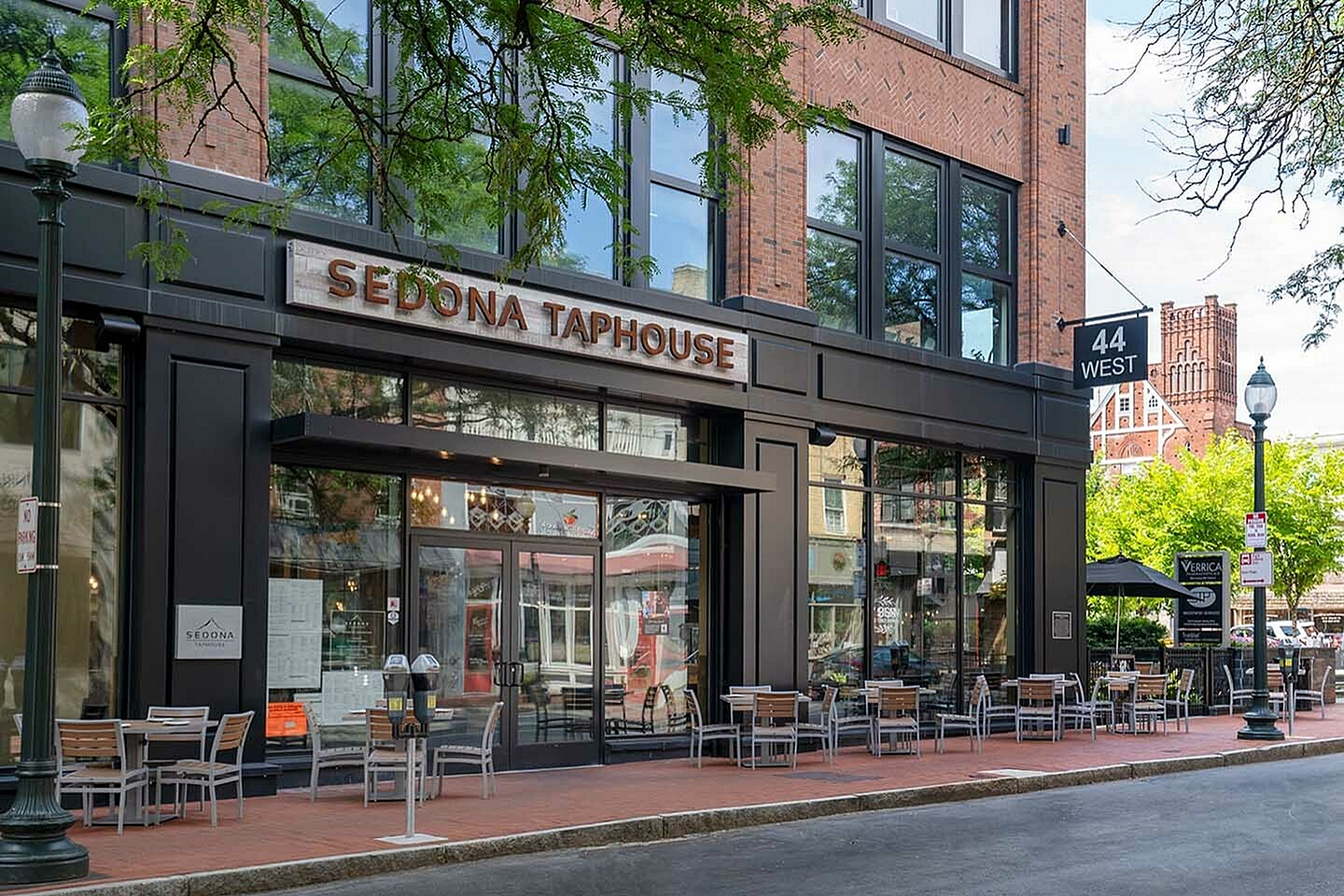 Charming urban restaurant exterior with inviting outdoor seating on a sunny street corner.