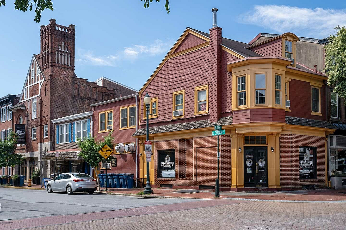 Charming corner building with historic architectural details and vibrant red and yellow accents, ideal for a stylish urban lifestyle.
