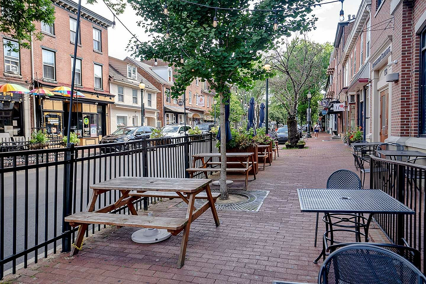 Charming urban streetscape with outdoor seating, vibrant shops, and tree-lined walkways, perfect for a leisurely stroll.