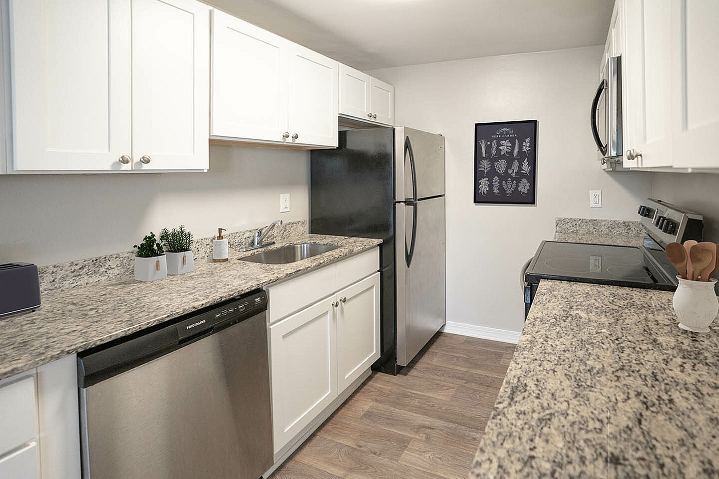 Sleek modern kitchen with granite countertops, stainless steel appliances, and elegant white cabinetry.