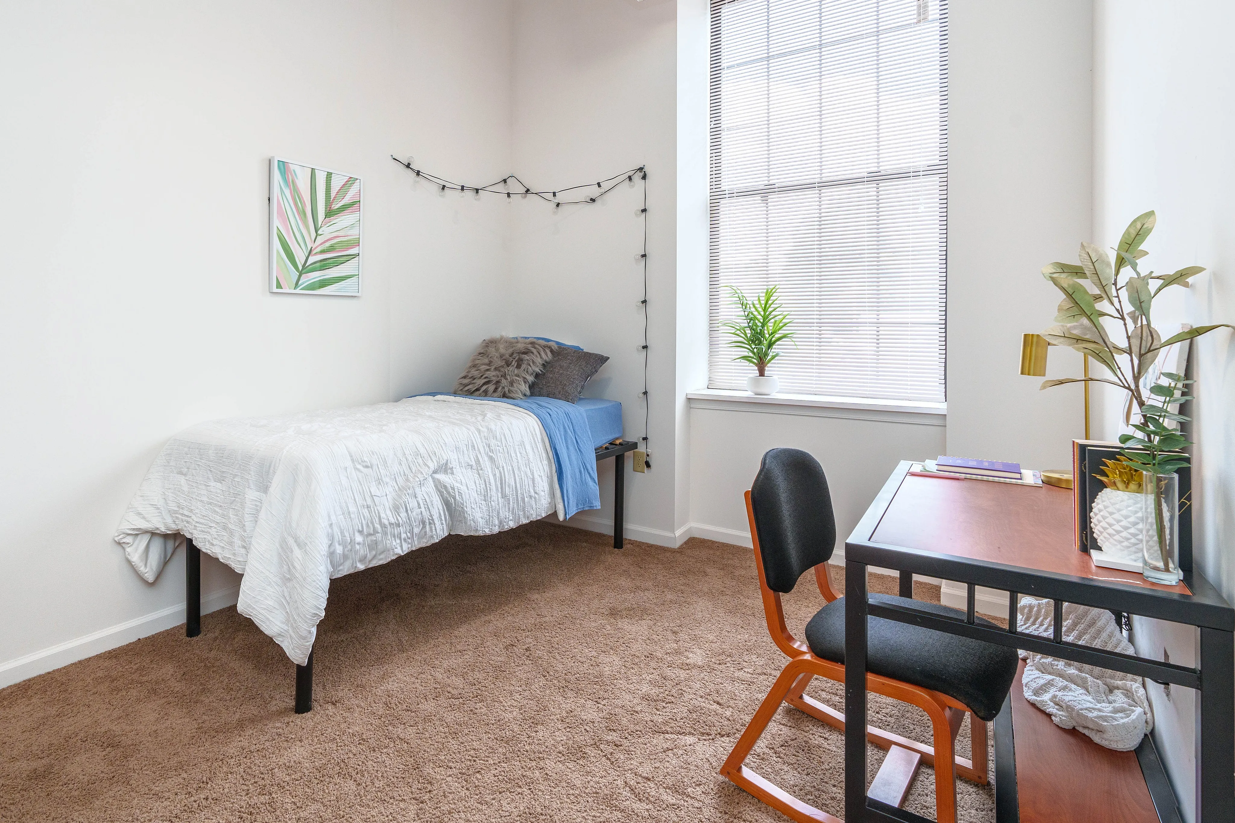Cozy and bright bedroom featuring a comfortable single bed with soft bedding, modern desk with stylish chair, and abundant natural light from a large window, perfect for a serene retreat.