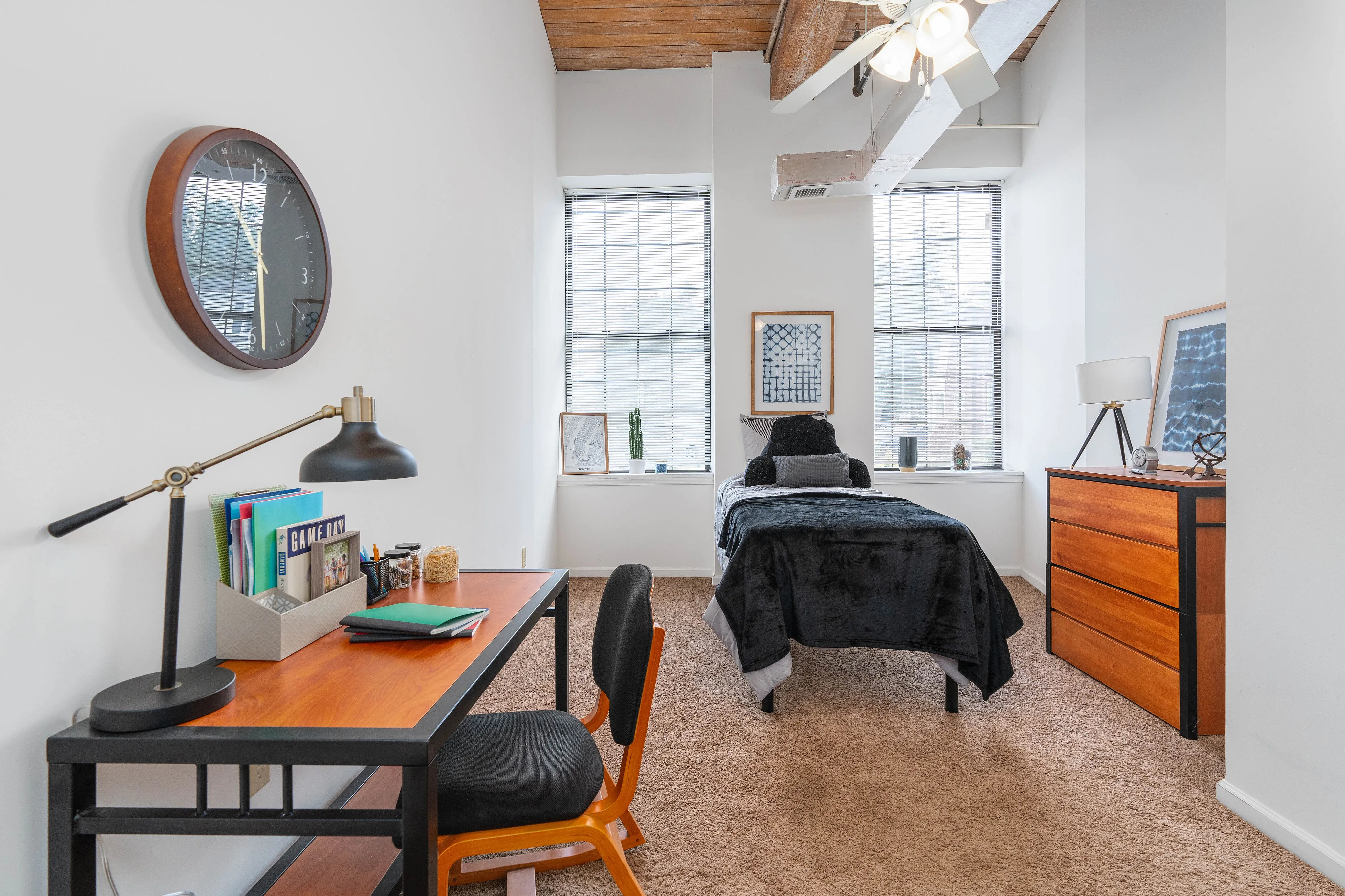 Chic and cozy bedroom with stylish desk setup, modern decor, and abundant natural light.