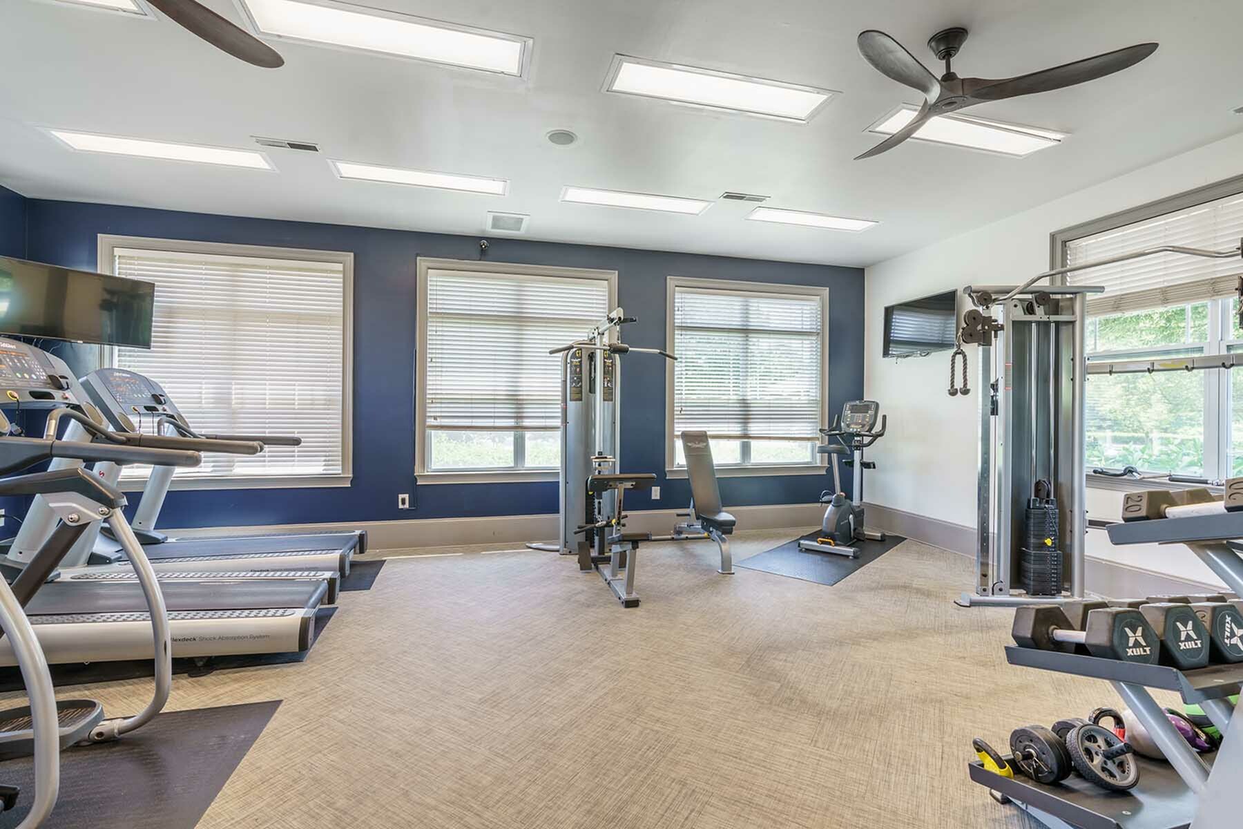 Bright and modern fitness center with state-of-the-art cardio equipment and weight machines, ideal for dynamic workouts.
