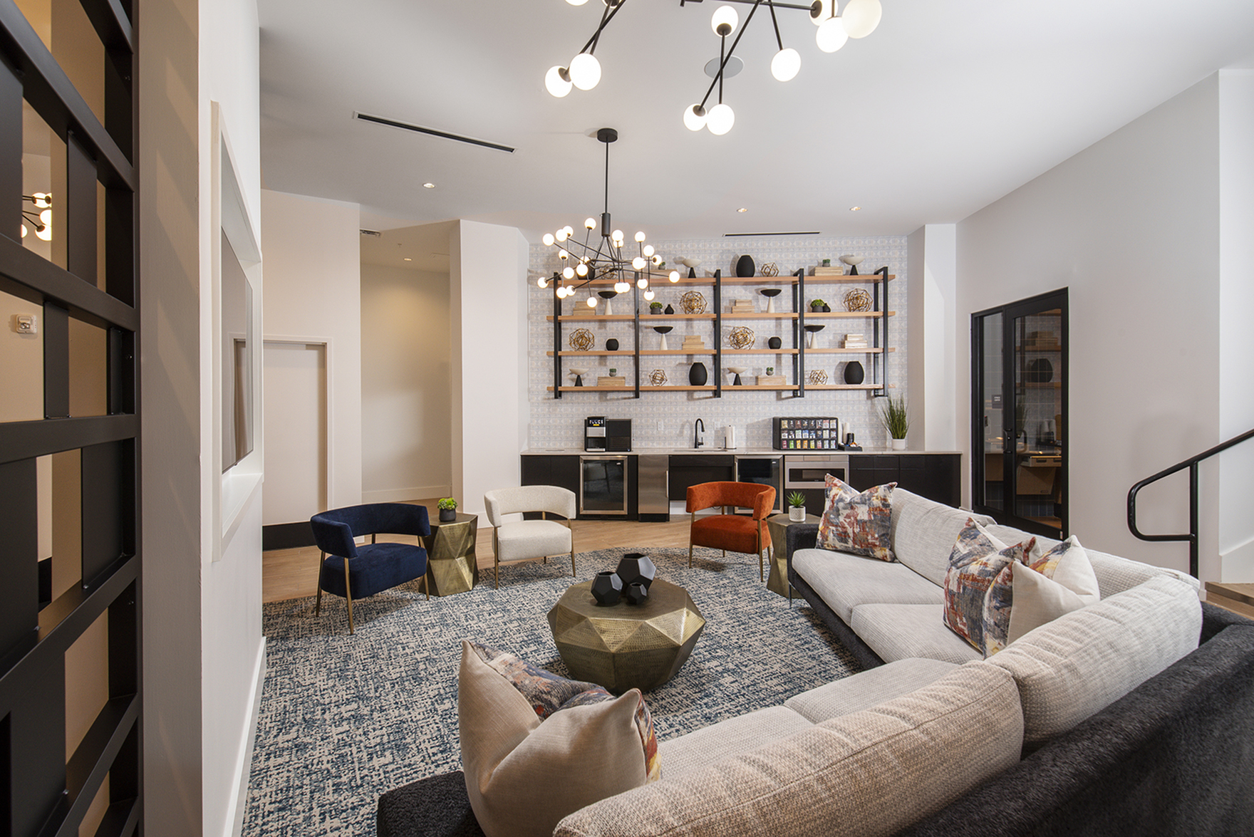 Elegant lounge area with modern chandelier, plush seating, and stylish shelving, perfect for relaxation and entertaining.