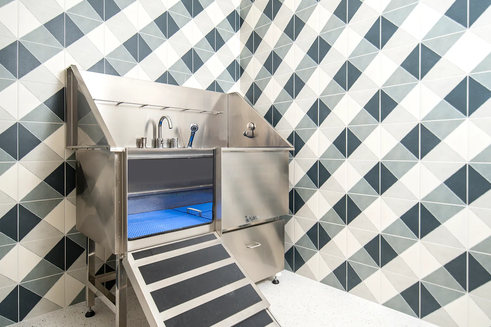 Sleek and modern pet wash station with geometric tile design and stainless steel finish, offering a luxurious experience.