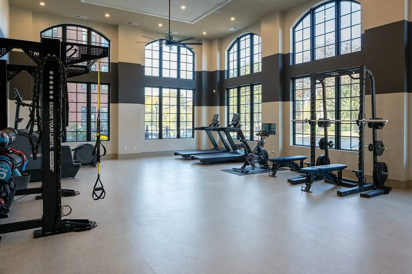 Modern fitness center with state-of-the-art equipment, large windows, and abundant natural light.