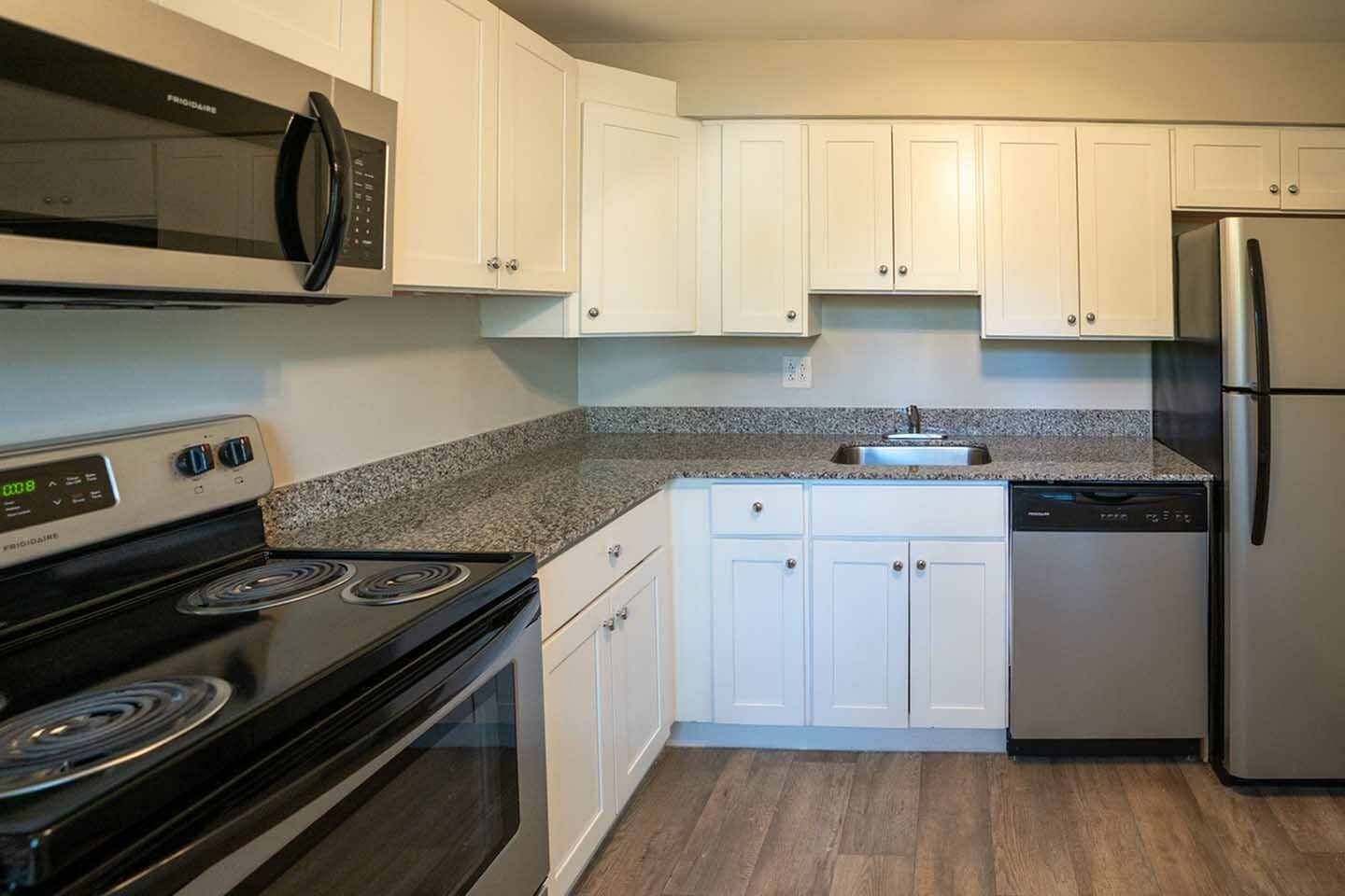 Modern kitchen with sleek stainless steel appliances, elegant granite countertops, and crisp white cabinetry for a sophisticated cooking experience.
