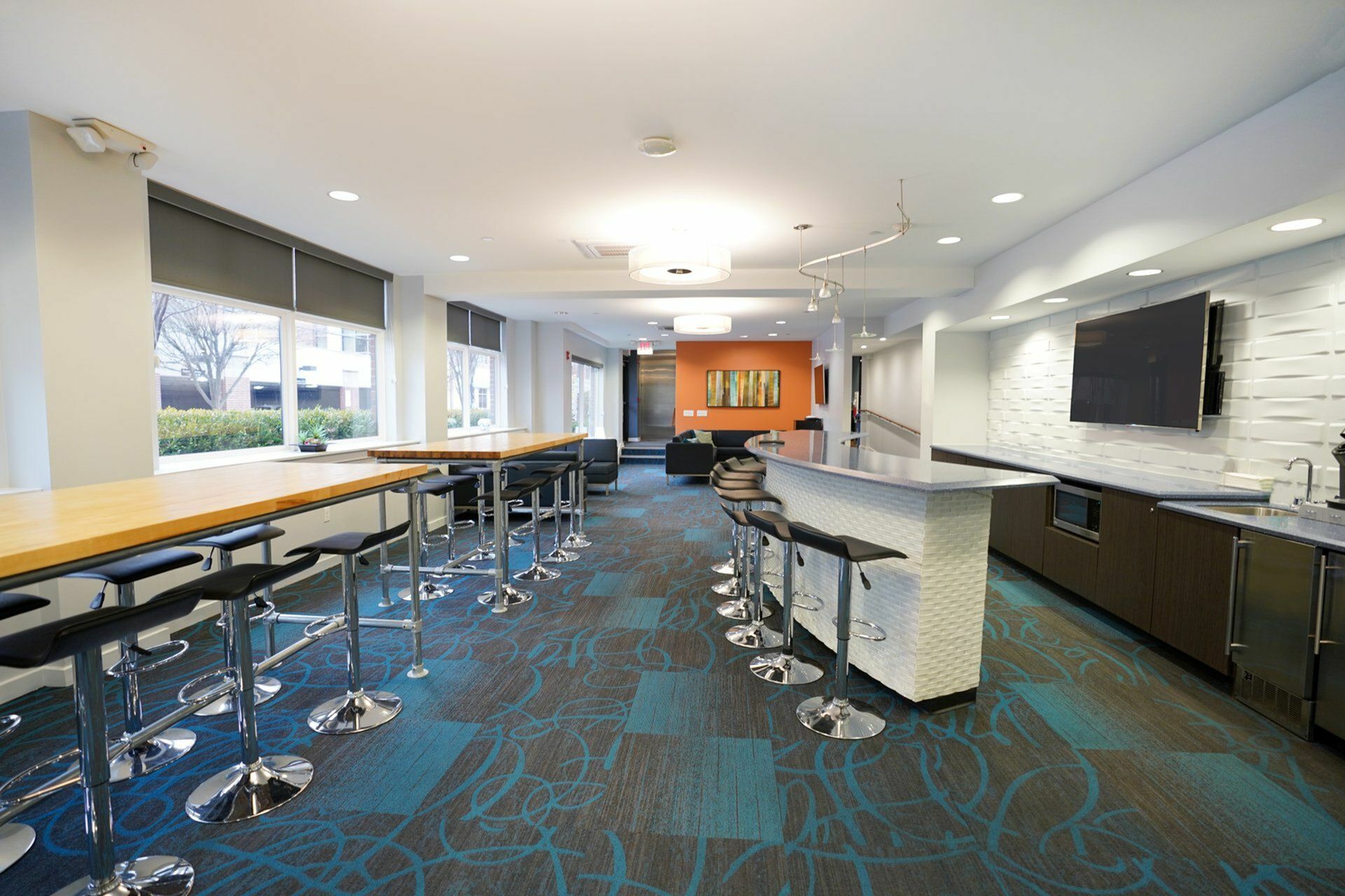Modern communal lounge with sleek bar seating, vibrant decor, and inviting natural light.