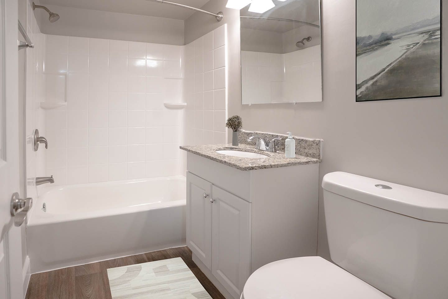 Modern bathroom with elegant granite countertop, spacious bathtub, and stylish tile accents.