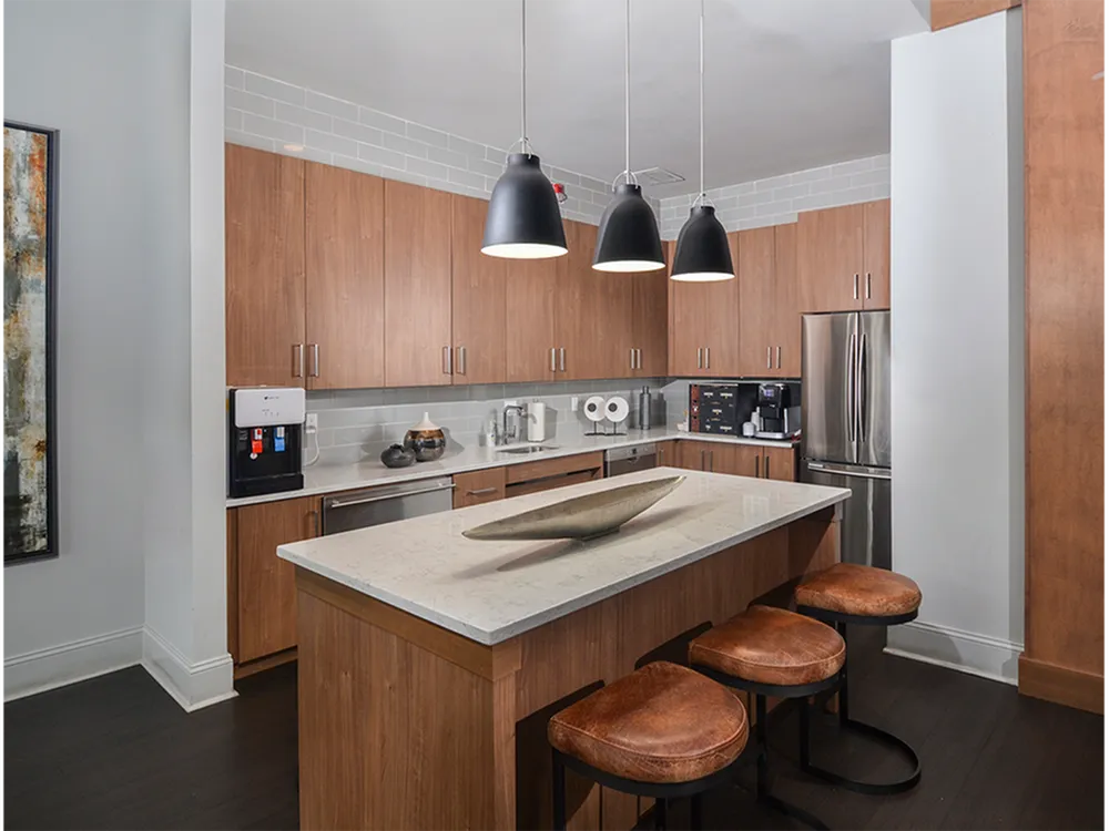 Modern kitchen with elegant wooden cabinets, sleek island counter with stylish lighting, and cozy bar stools.