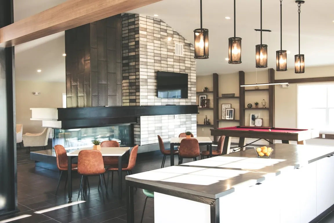 Chic and modern open-concept living space featuring a stylish dining area, sleek kitchen island, cozy fireplace, and elegant lighting.