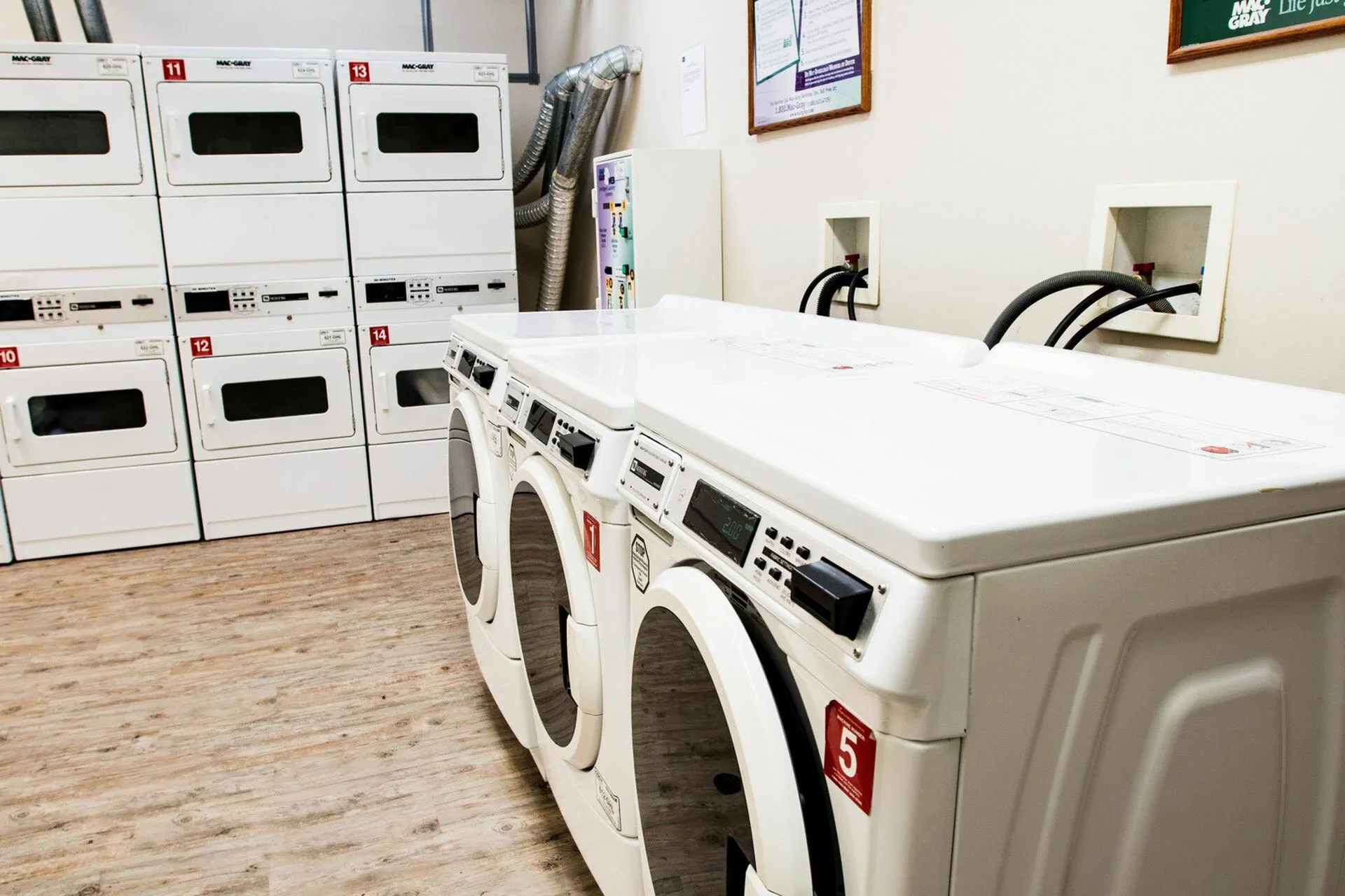 Modern laundry room with multiple stacked washers and dryers, offering convenience and efficiency for residents.