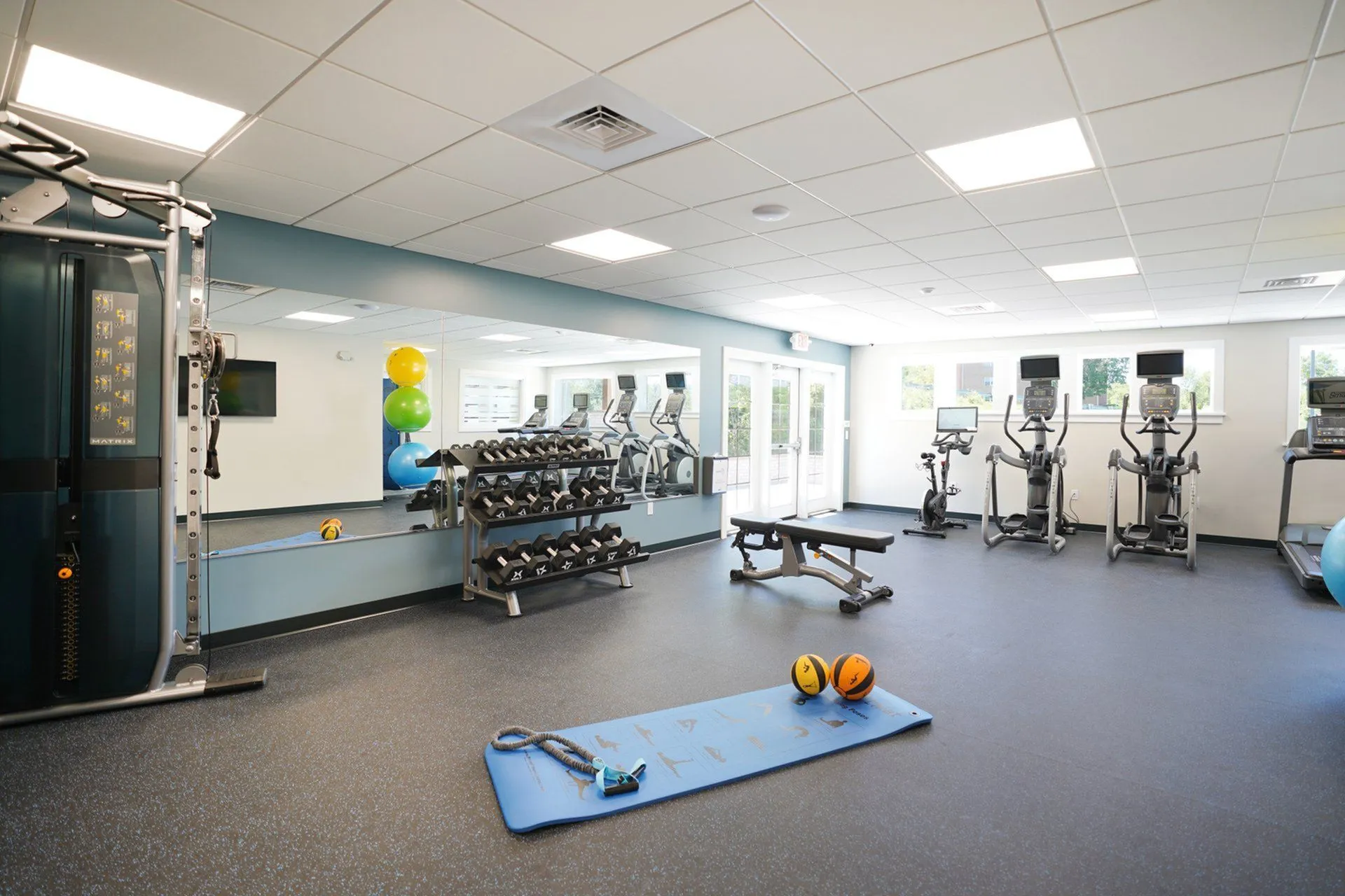 Modern fitness center with state-of-the-art equipment, spacious layout, and vibrant accents.