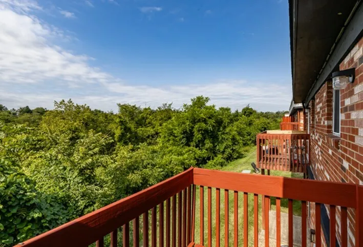 Charming balcony view showcasing lush green landscape and vibrant skies, perfect for nature lovers seeking tranquility.