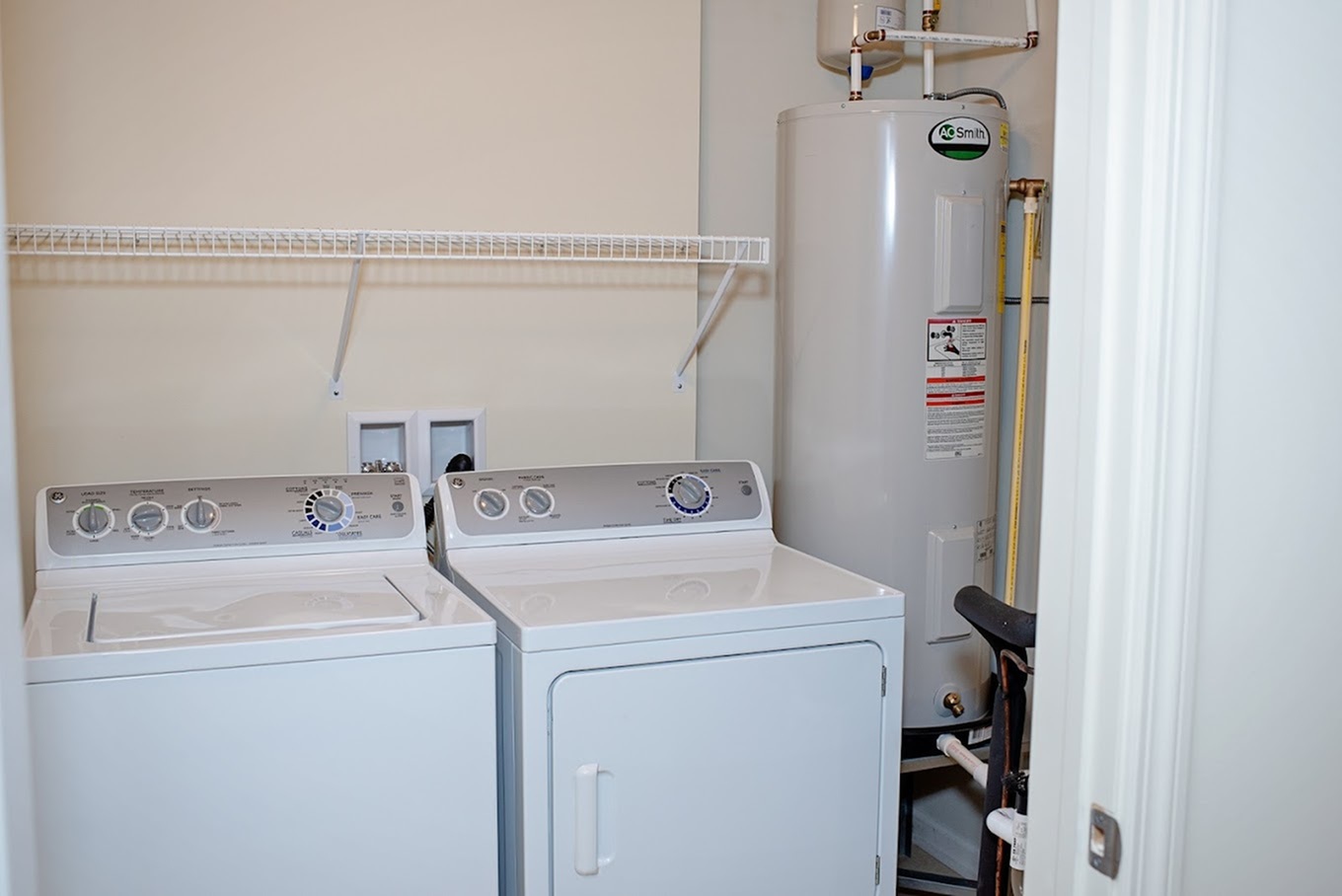 Efficient laundry area with modern washer, dryer, and water heater, maximizing utility space.