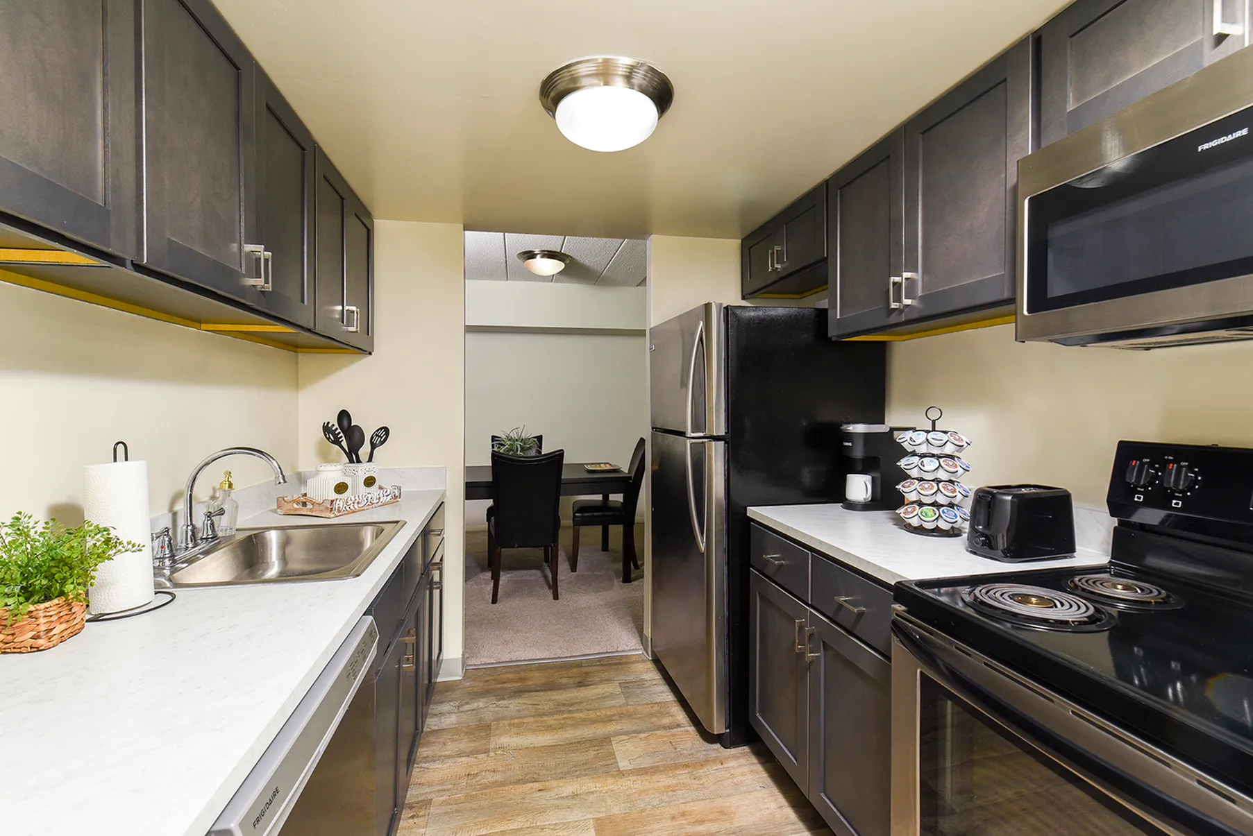 Modern kitchen with sleek dark cabinets, stainless steel appliances, and inviting dining area.