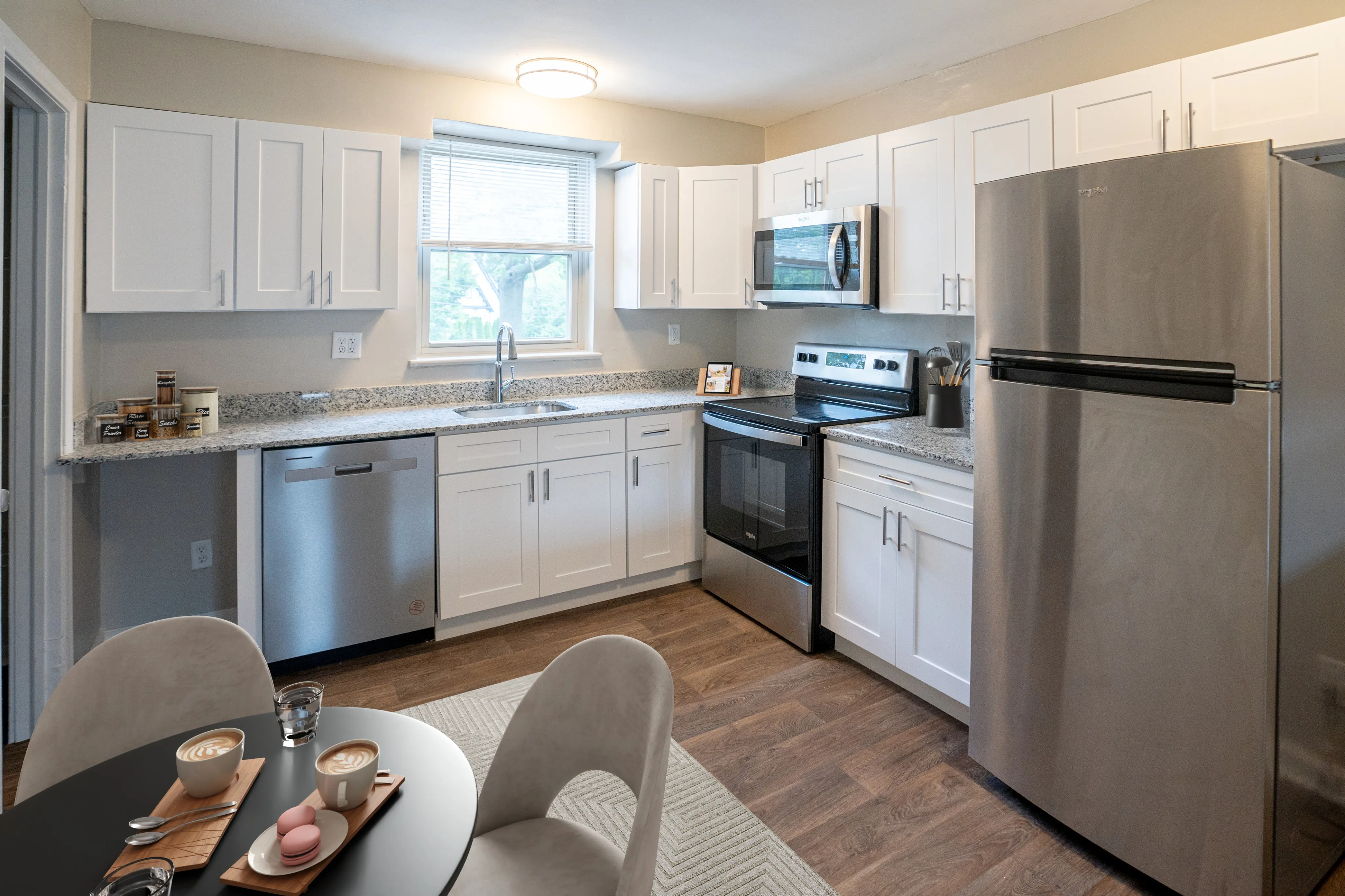 Modern kitchen with sleek stainless steel appliances, elegant granite countertops, and contemporary white cabinetry, creating a bright and inviting culinary space.