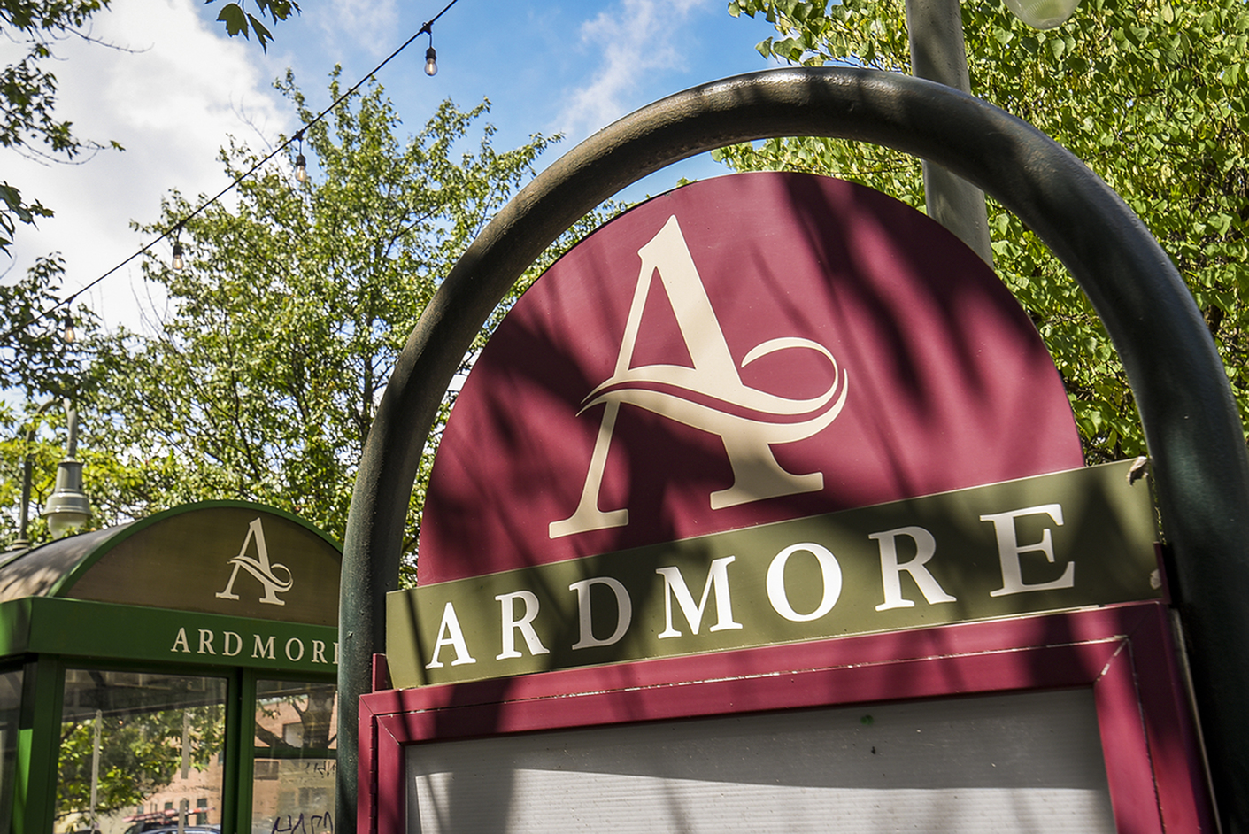 Charming entrance sign of Ardmore surrounded by lush greenery and a clear blue sky, creating a welcoming atmosphere.