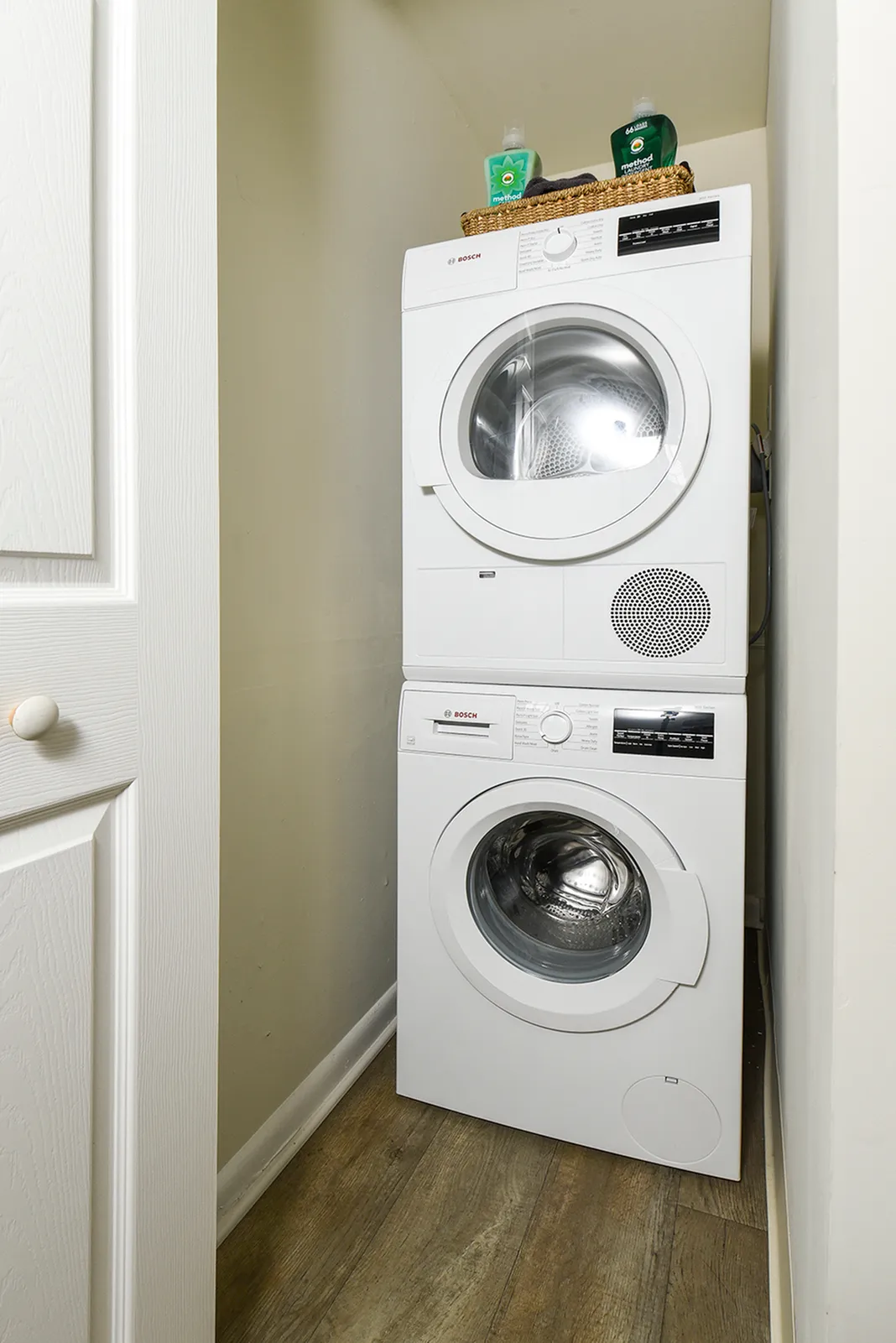 Compact in-unit laundry with modern Bosch washer and dryer, featuring sleek white design and efficient space-saving stack.
