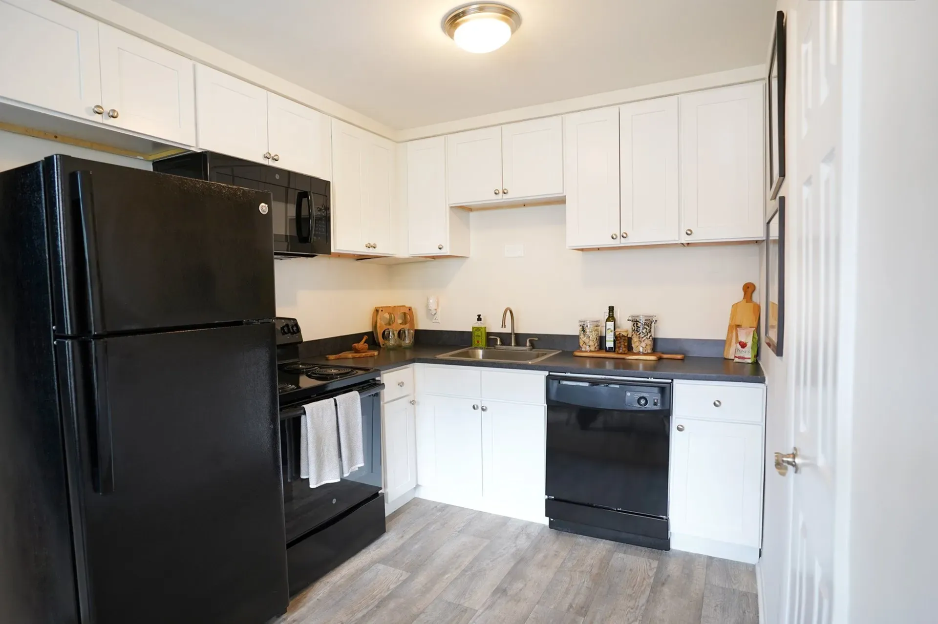 Modern kitchen with sleek black appliances, elegant white cabinetry, and ample counter space.