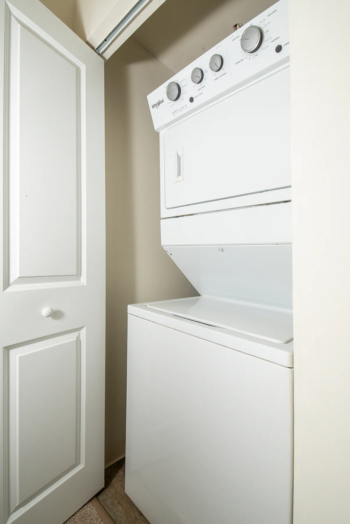 Convenient in-unit laundry space featuring a sleek stacked washer and dryer set within a white closet.