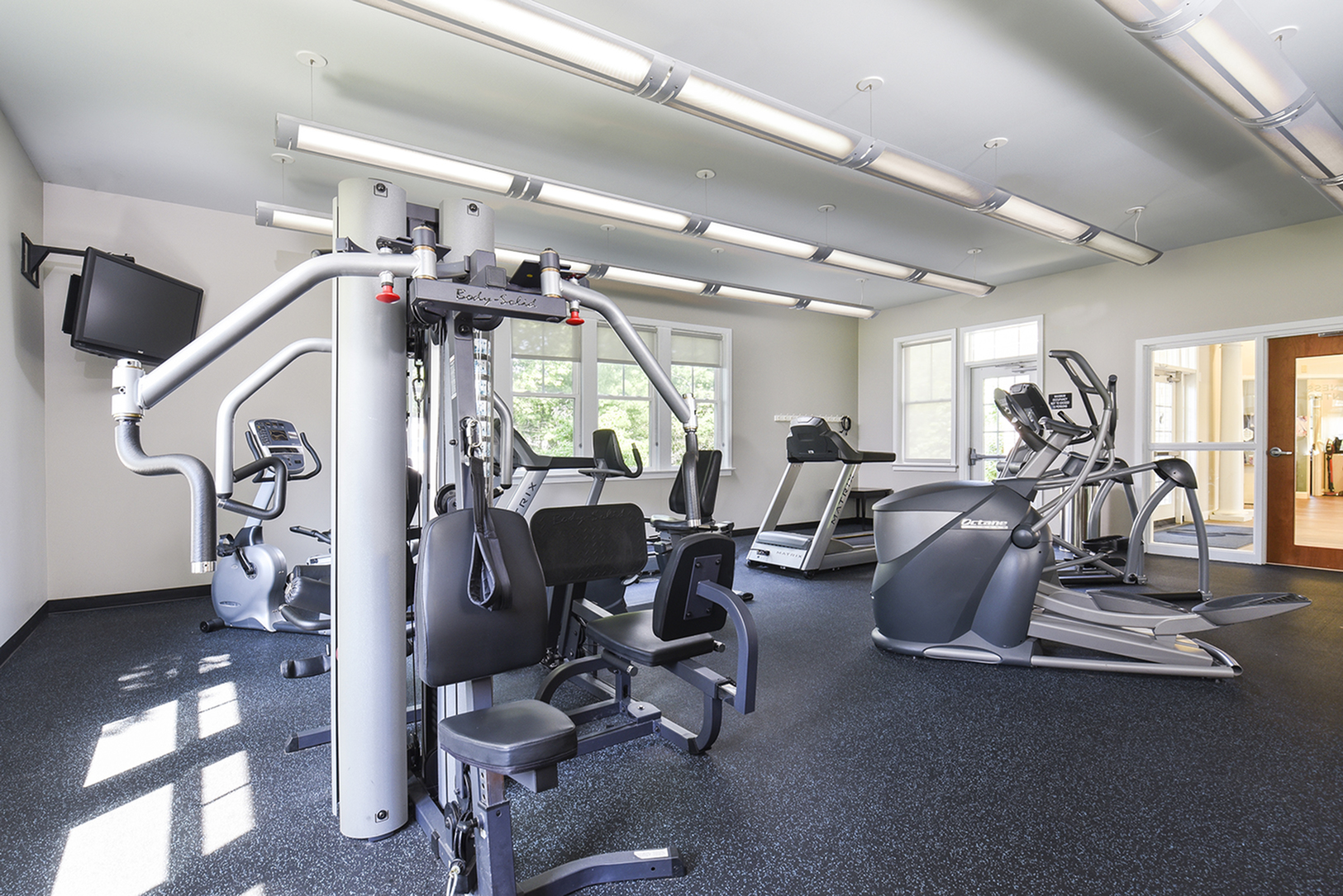 Modern fitness center featuring state-of-the-art gym equipment, bright spacious interior with natural light.