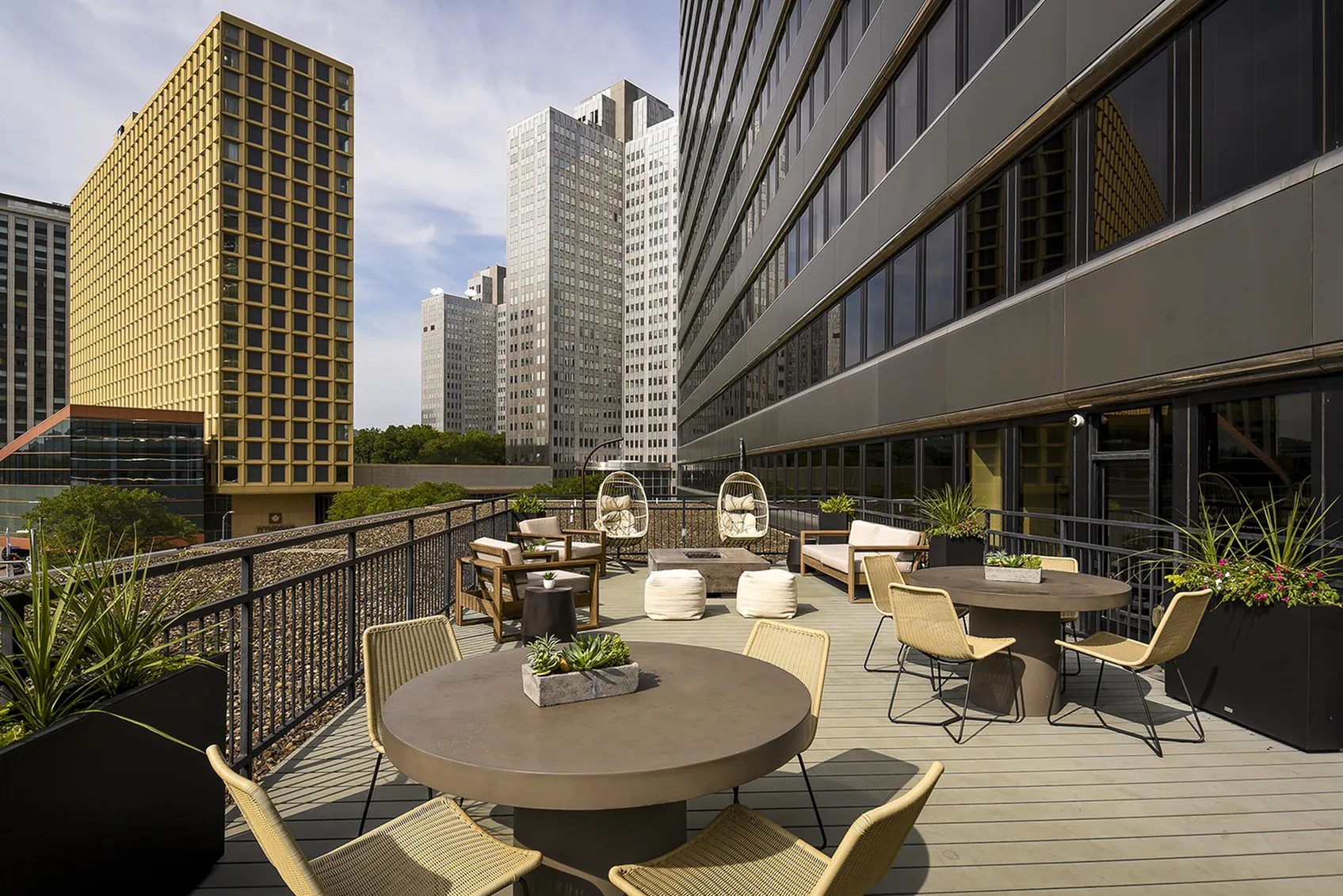Chic urban patio with stylish seating, surrounded by modern skyscrapers, offering a perfect city view retreat.