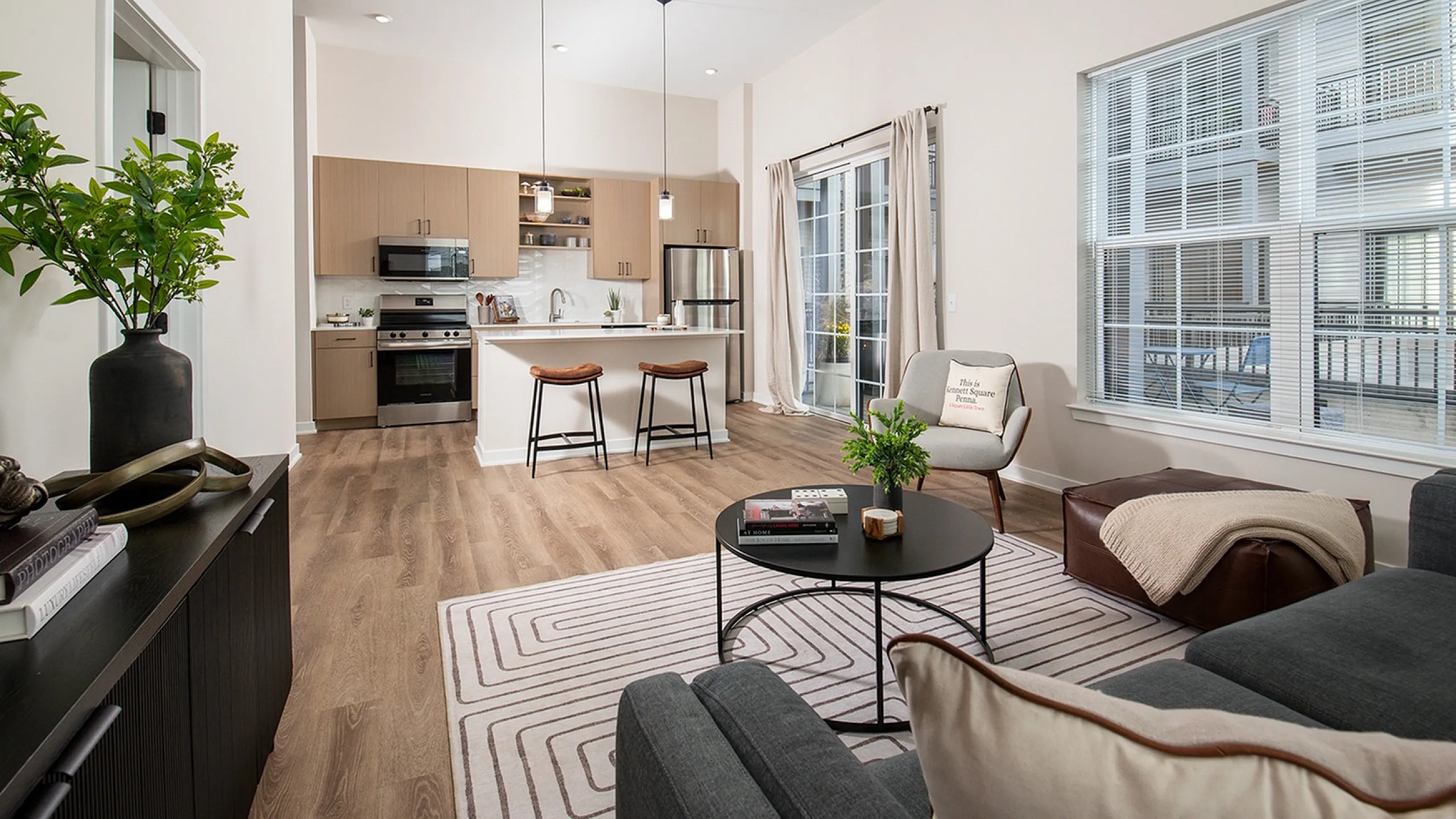 Bright open-concept living room and kitchen with modern furnishings and natural light.