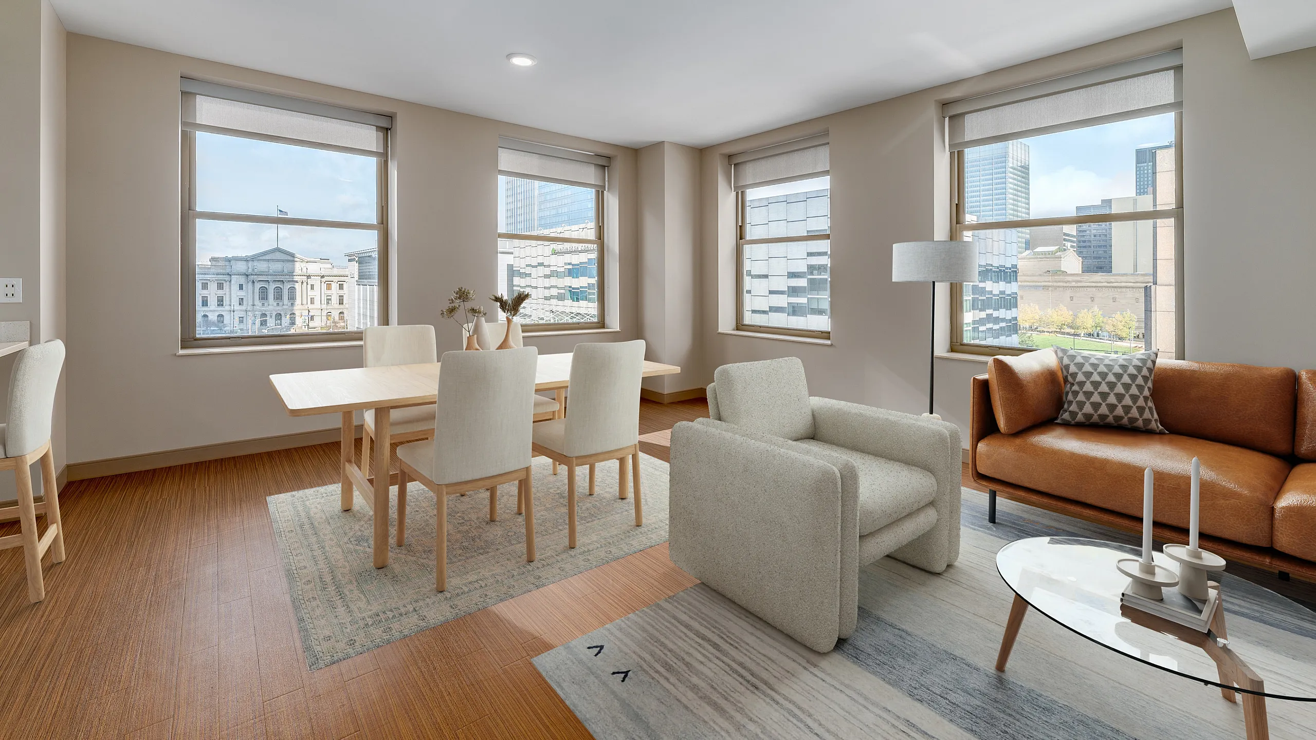 Bright urban living room with modern furniture, large windows, and city views.