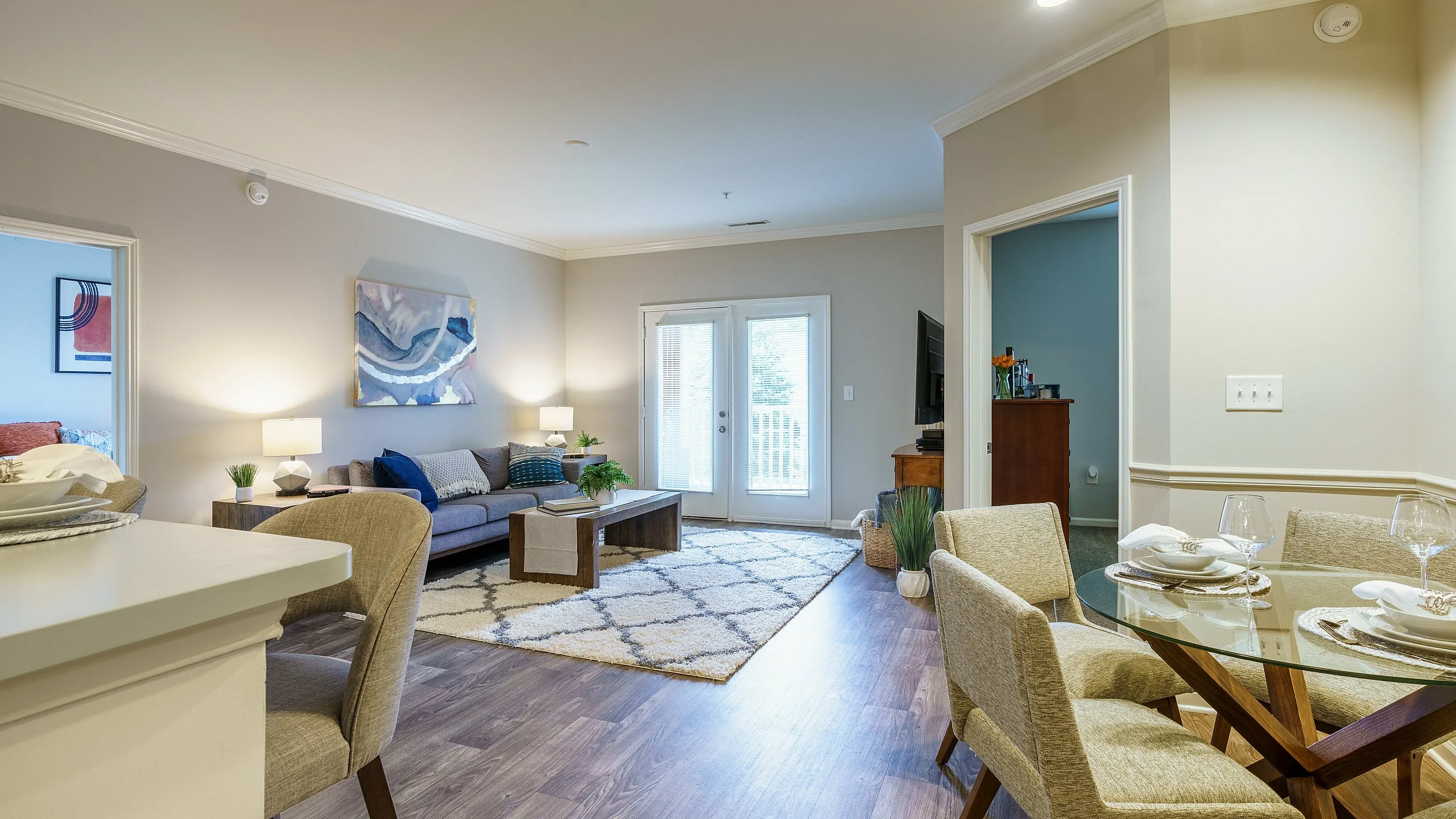 Inviting open-plan living room with a cozy seating area, stylish dining set, and bright natural light.