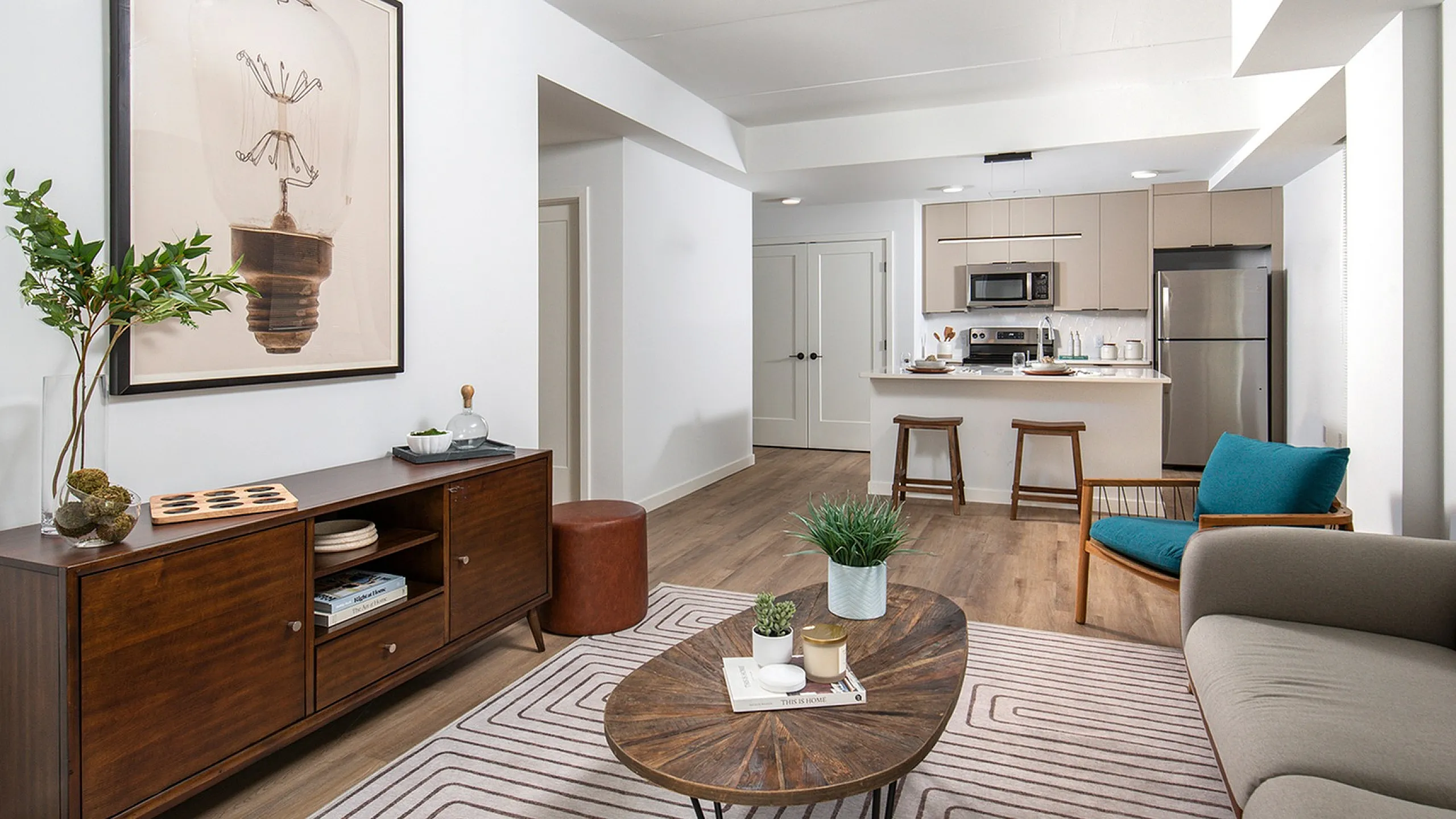 Bright and modern living space featuring stylish decor, comfortable seating, and a sleek kitchen with stainless steel appliances.