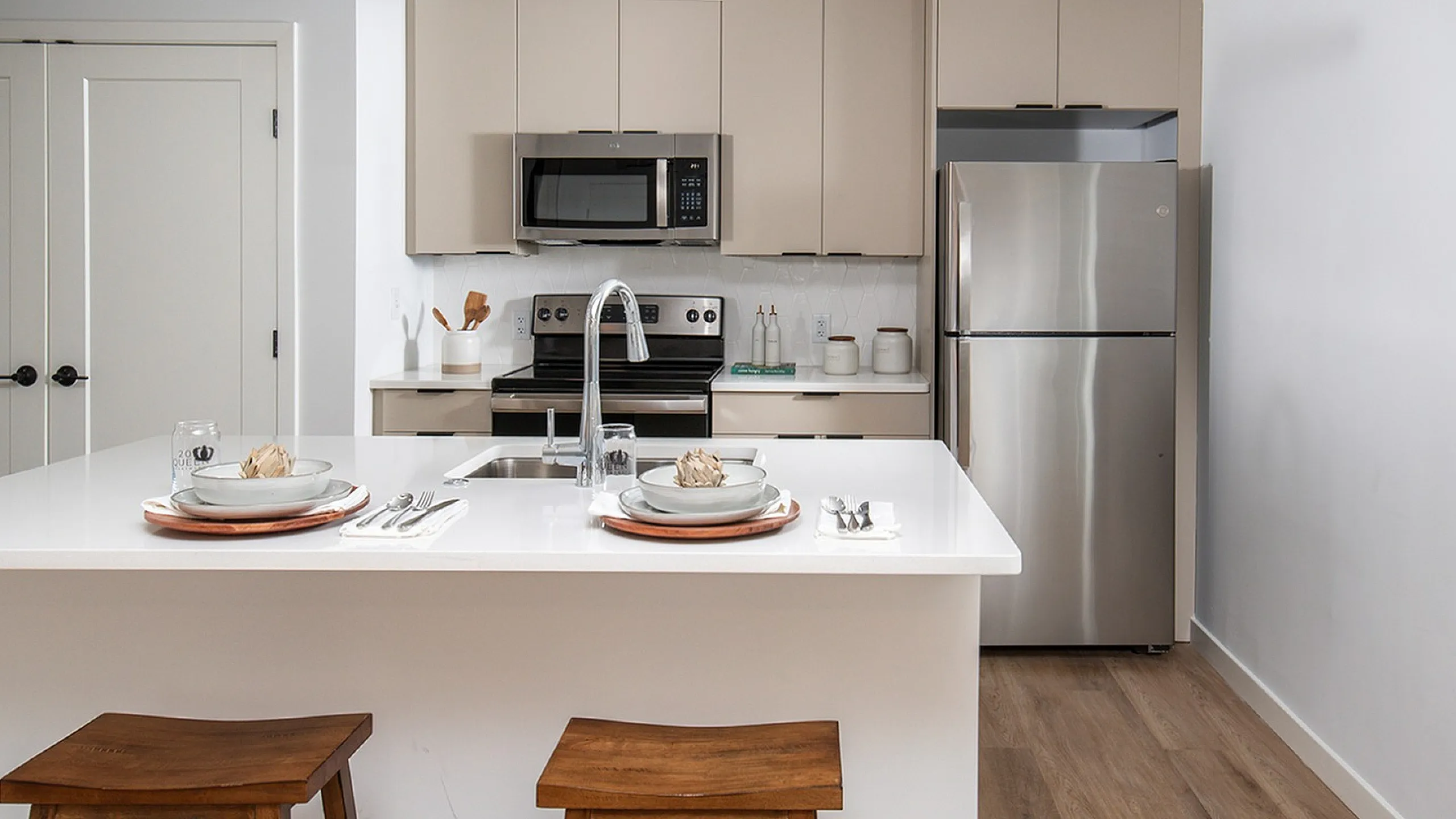 Modern kitchen with a sleek island, stainless steel appliances, and chic white cabinetry, perfect for gourmet cooking.