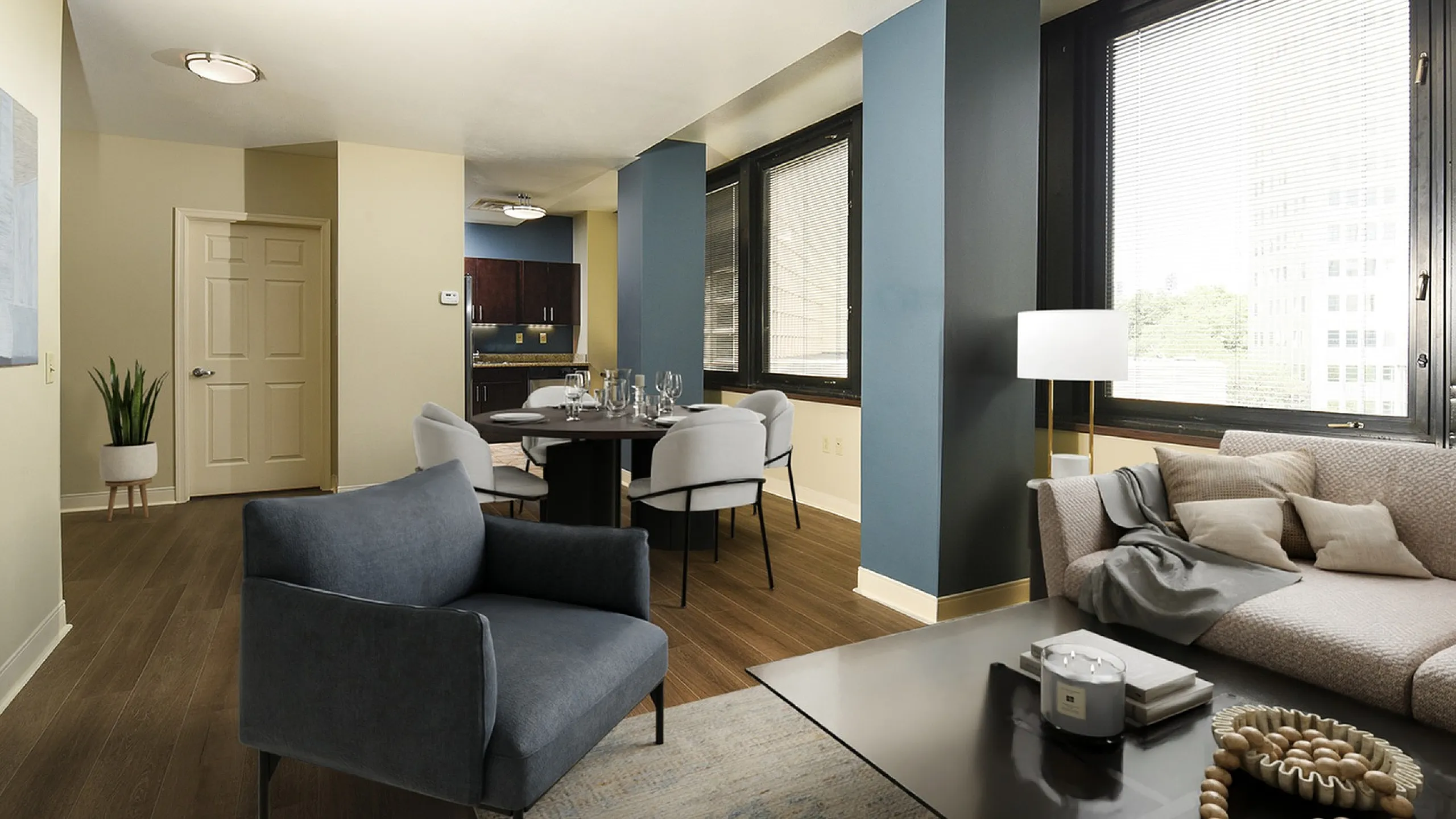 Modern apartment interior with stylish open-concept living room, cozy seating, and elegant dining area, featuring large windows for natural light.