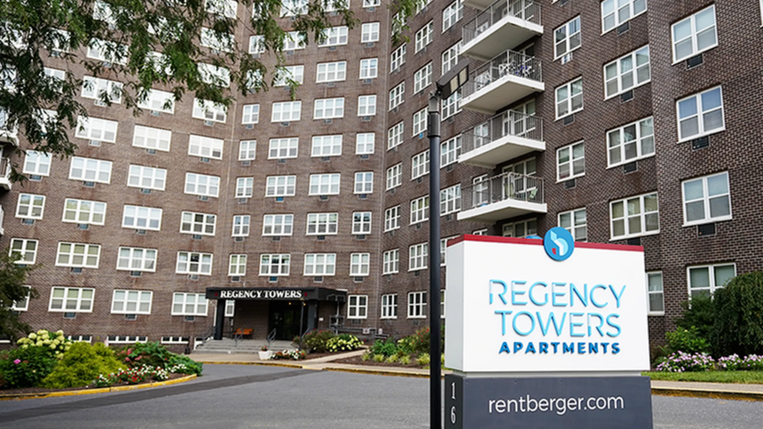 Inviting exterior view of Regency Towers Apartments, showcasing modern architecture and lush landscaping.