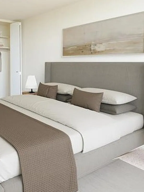 Elegant bedroom with a plush bed, built-in wardrobe, and soft lighting for a serene living experience.