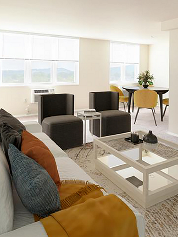 Bright and modern living room with cozy seating, elegant decor, and expansive windows offering scenic views.