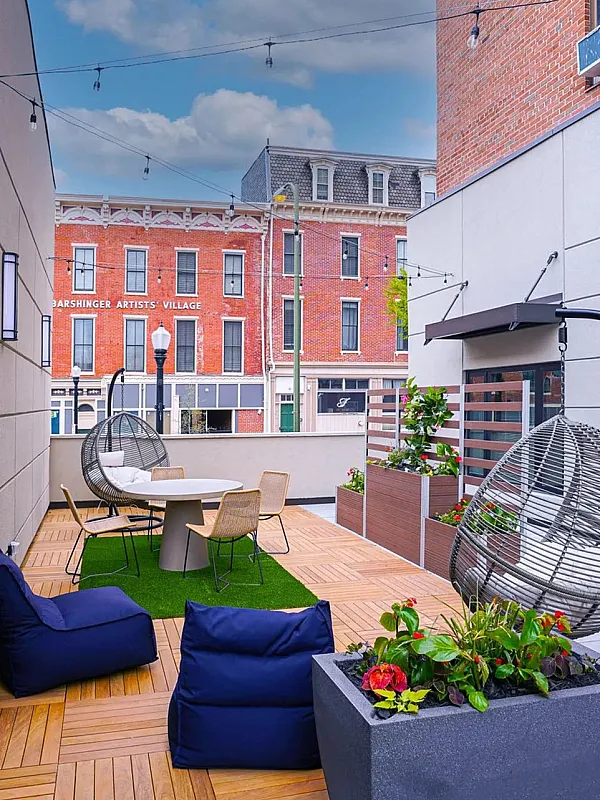Chic urban patio showcasing modern seating, lush planters, and inviting atmosphere under string lights.