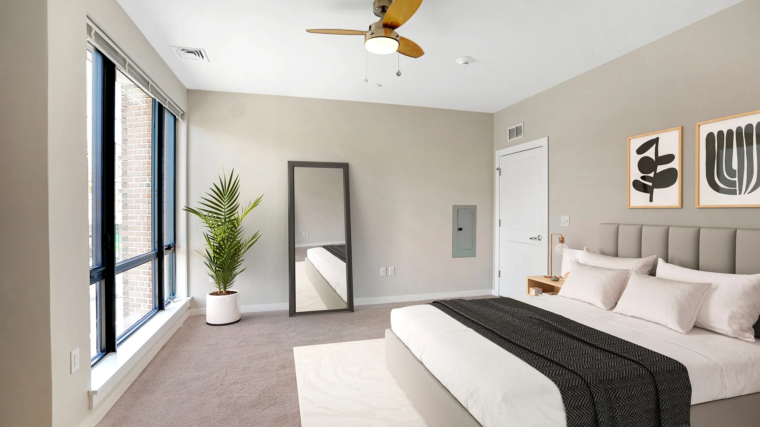 Bright and inviting bedroom with modern decor, large windows, and elegant ceiling fan, perfect for a cozy retreat.