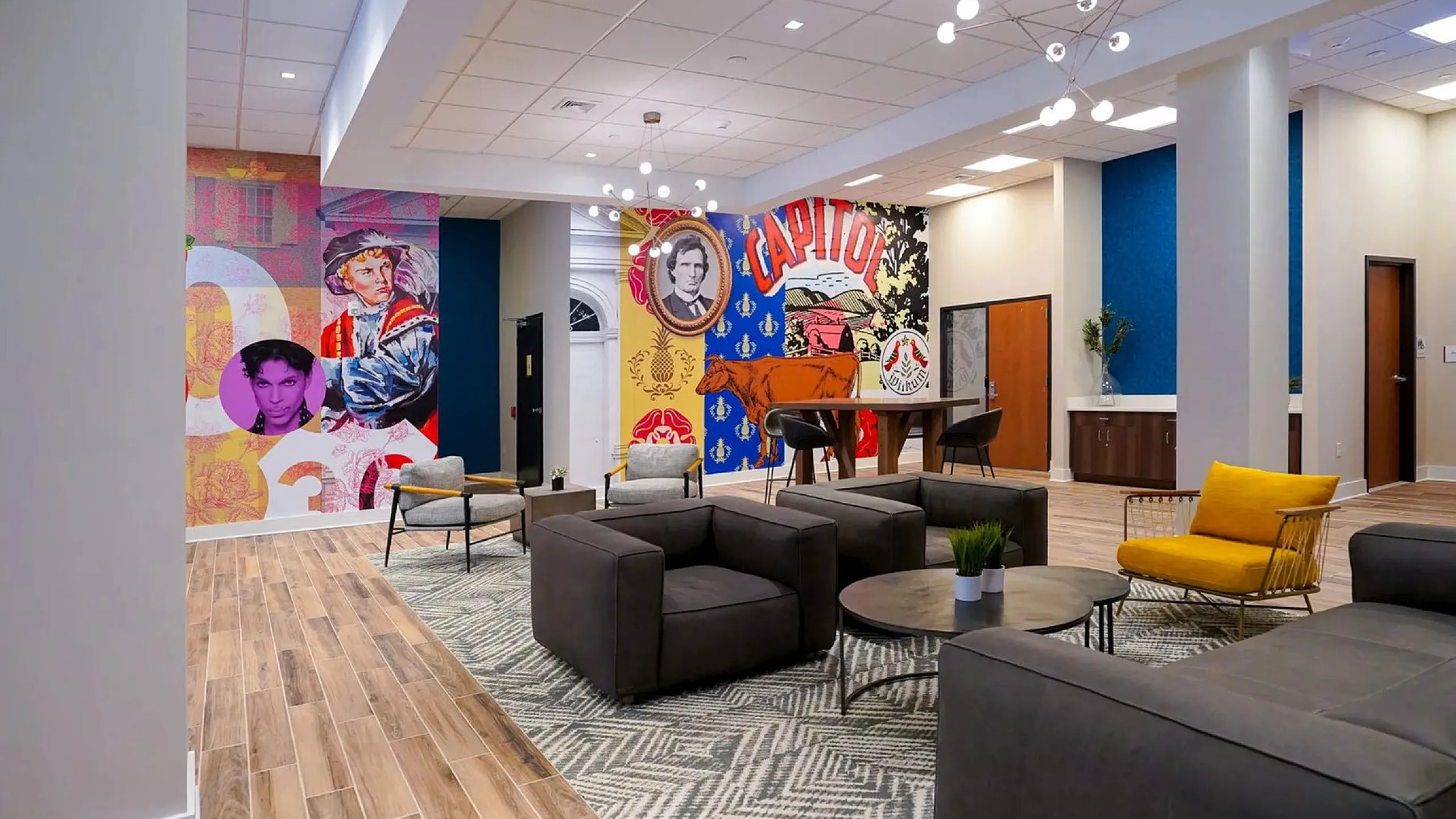 Contemporary lobby lounge with modern art murals, stylish seating, and a chic chandelier.