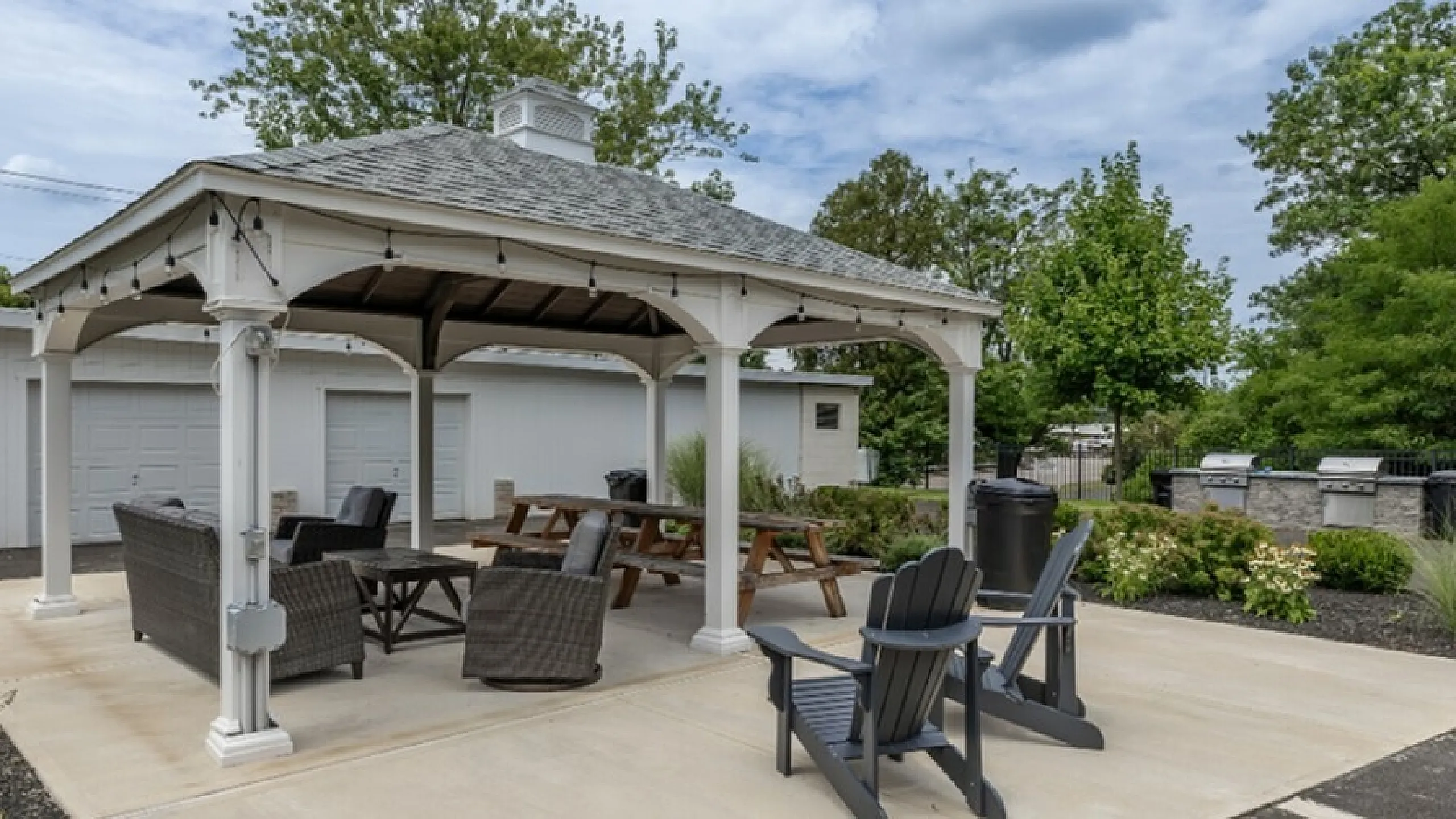 Charming outdoor gazebo area with stylish seating, perfect for relaxation or social gatherings, surrounded by lush greenery.