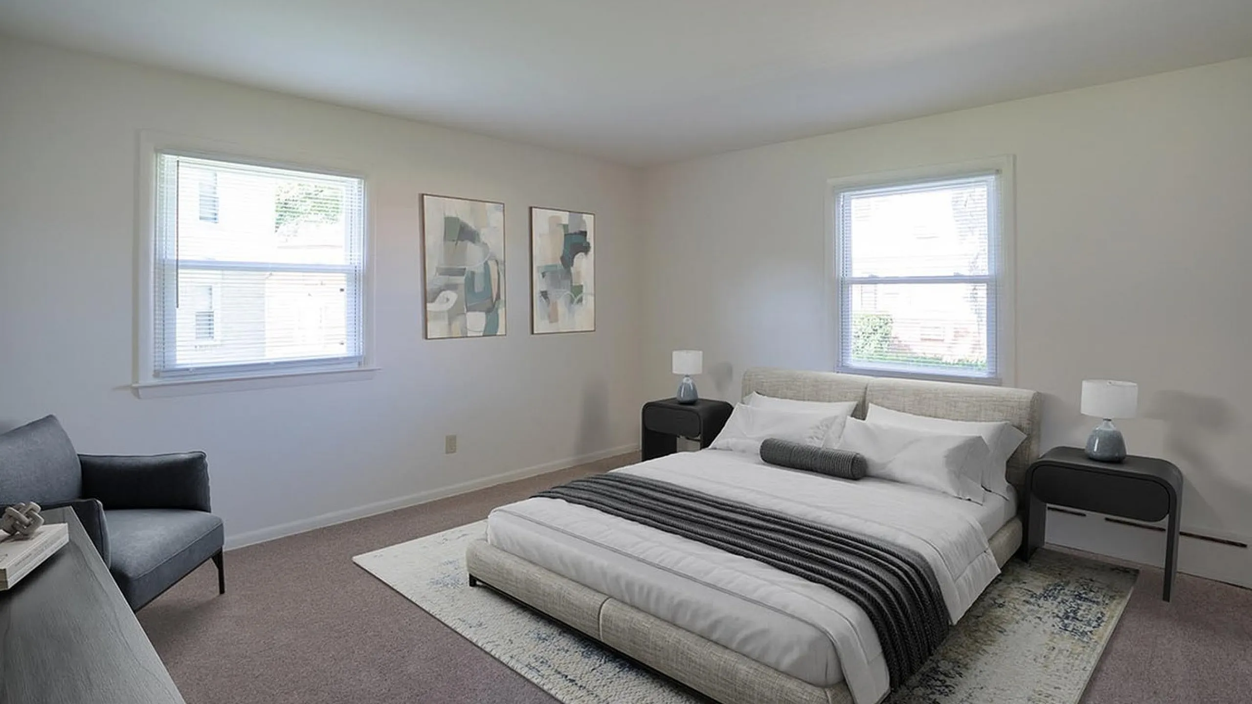Bright and elegant bedroom with modern decor, featuring large windows, stylish artwork, and a plush bed for ultimate comfort.