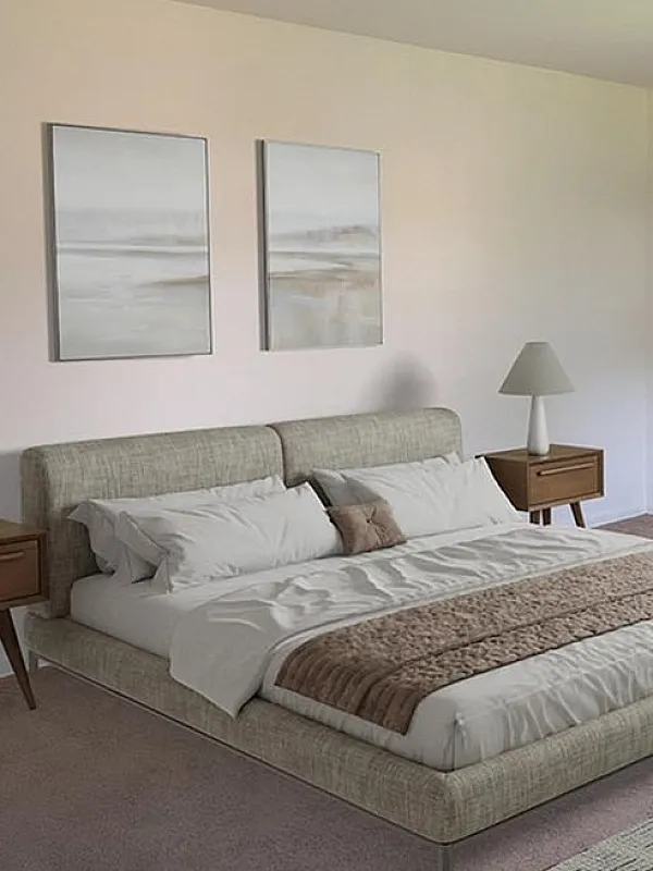 Inviting bedroom with modern decor, including a plush bed, stylish artwork, and cozy seating area.