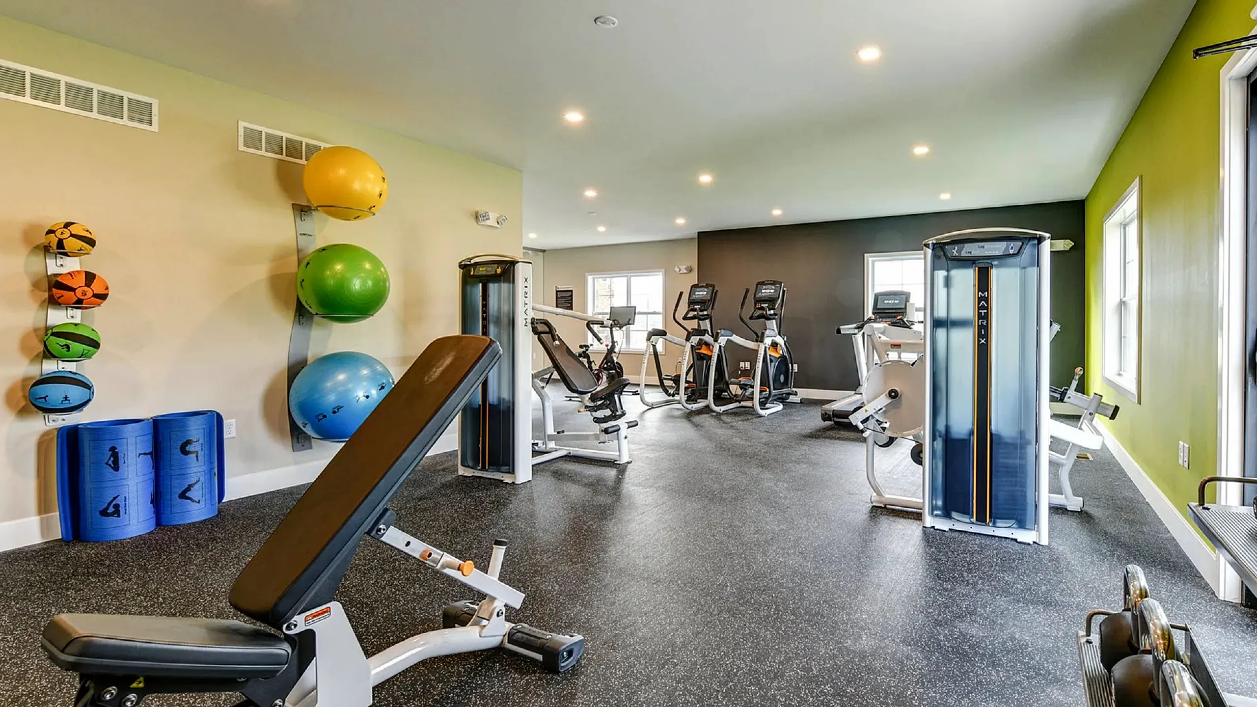 Modern gym facility with state-of-the-art equipment, vibrant decor, and ample natural lighting for an invigorating workout experience.