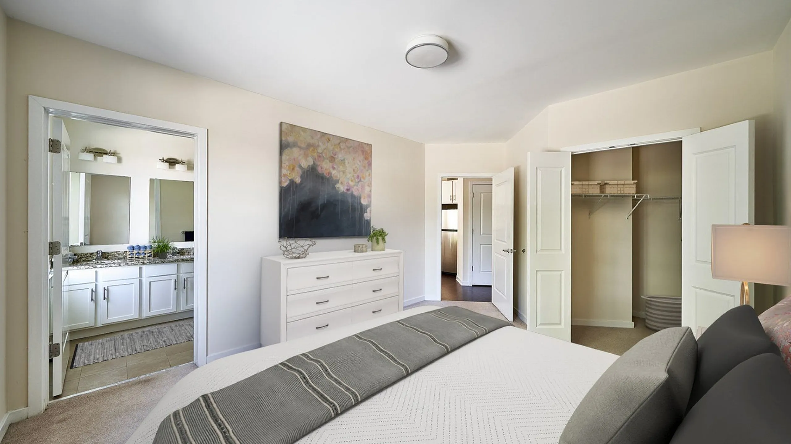 Elegant bedroom with en-suite bathroom, featuring a cozy bed, spacious closet, and chic decor.