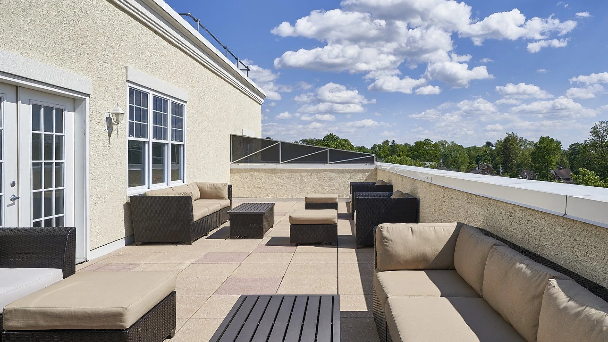 Luxurious rooftop terrace with comfortable seating and expansive views under a clear blue sky.