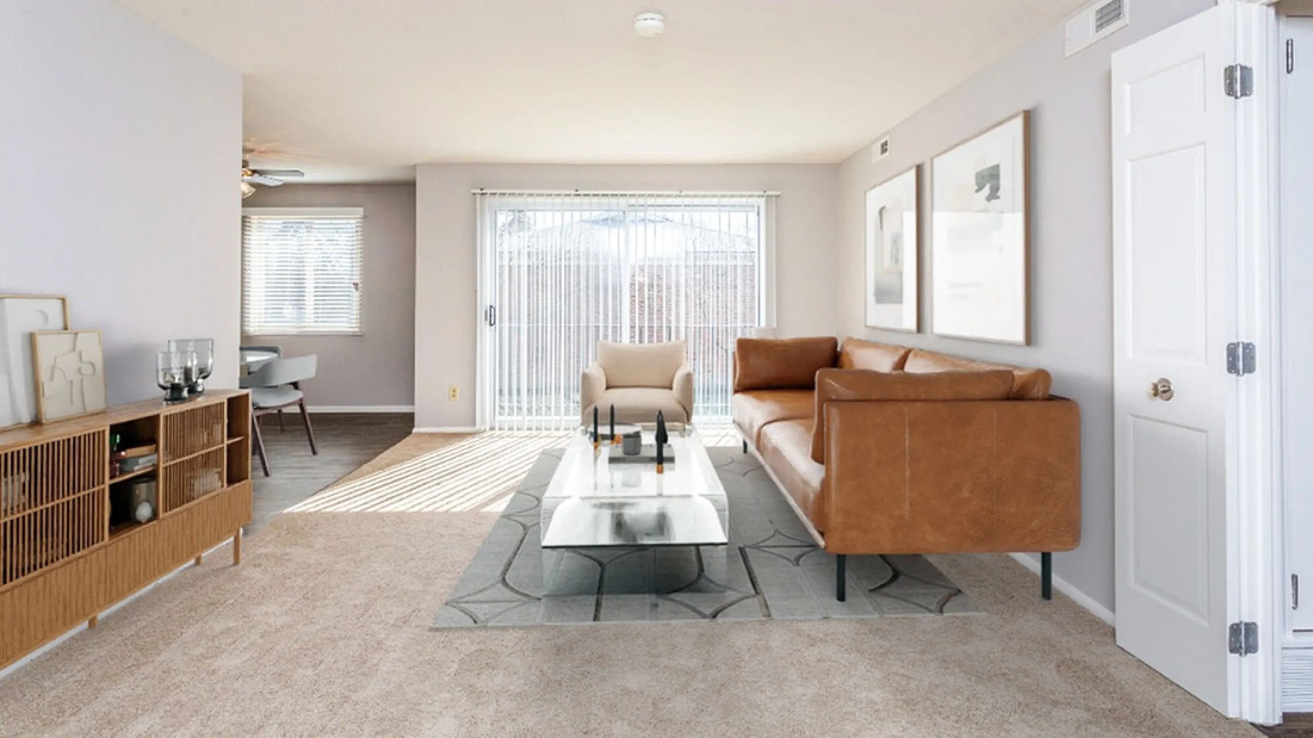 Bright and inviting living area with plush seating, modern decor, and expansive sliding glass doors opening to natural light.