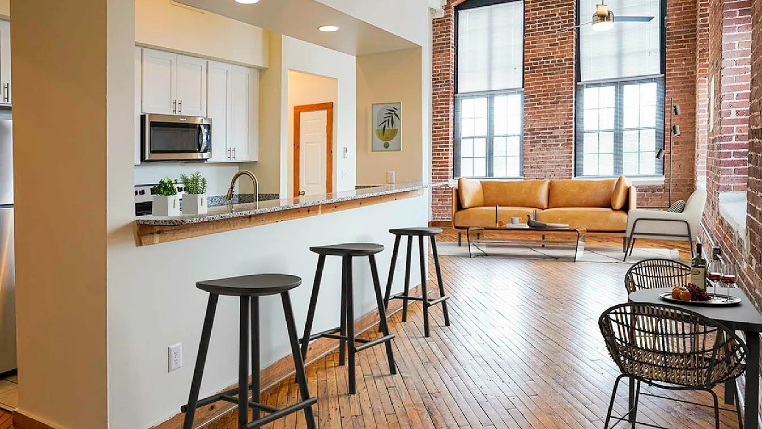 Chic urban loft with exposed brick walls, modern kitchen, and cozy living area with stylish seating.