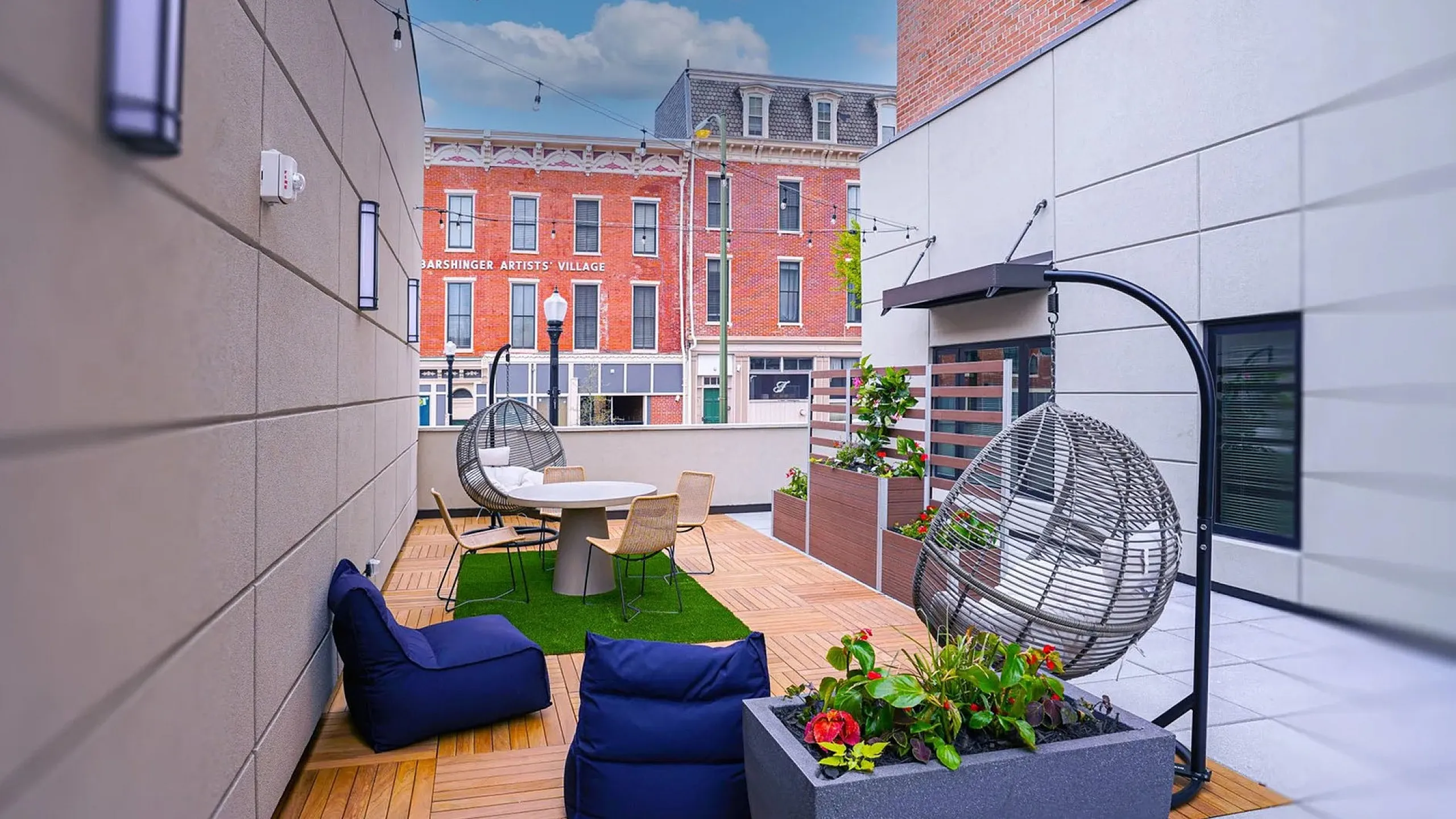 Chic urban rooftop patio with modern seating, vibrant plants, and city views, perfect for relaxation or entertaining.